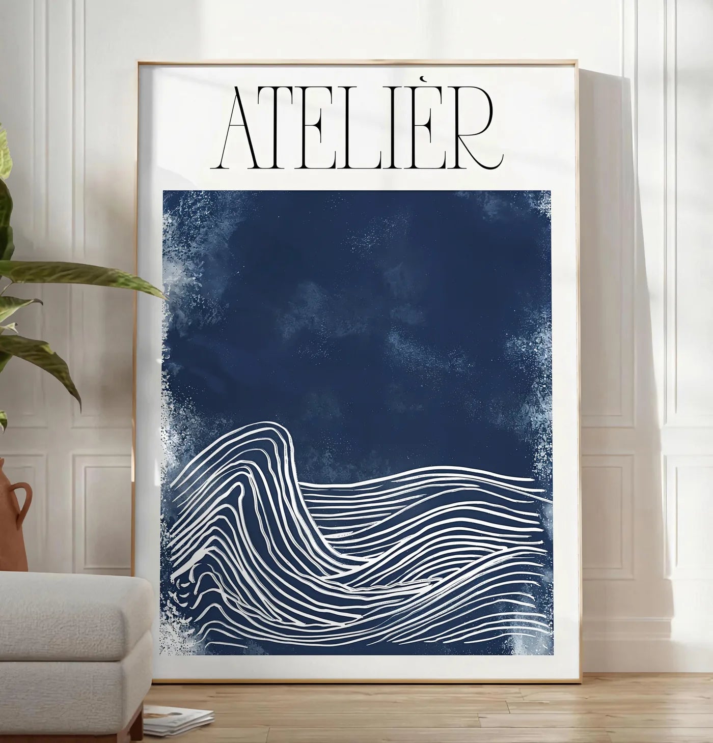Reproduction affiche Atelier vagues minimaliste, posee au sol dans un salon minimaliste clair, a cote d'un canape beige et d'une plante verte, sur un parquet clair