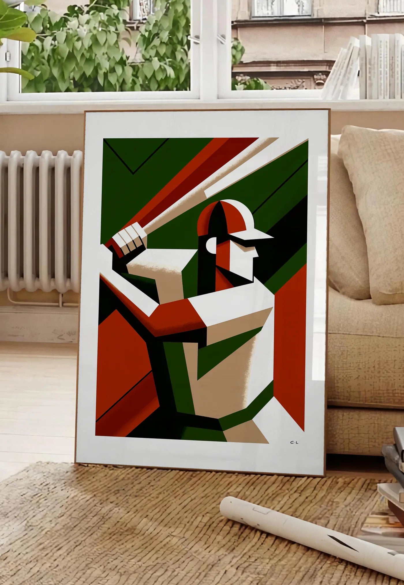 Poster joueur de baseball en position de frappe, posee au sol dans un salon parisien, devant une grande fenetre donnant sur un immeuble haussmannien, entre un ficus et un canape creme