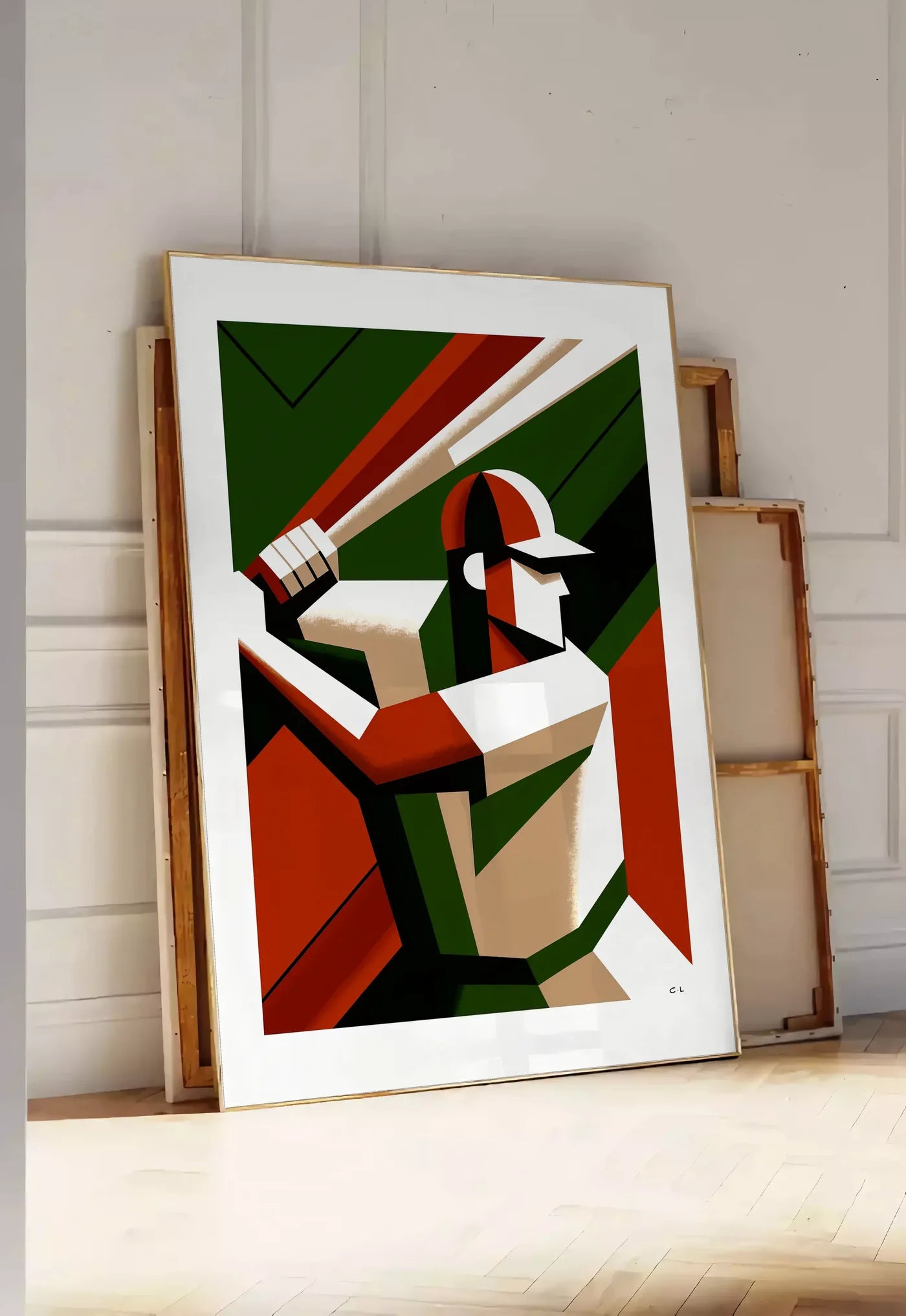 Tirage encadrable joueur de baseball en position de frappe, posee au sol dans une entree lumineuse, contre un mur a panneaux blancs, a cote de chassis en bois empiles