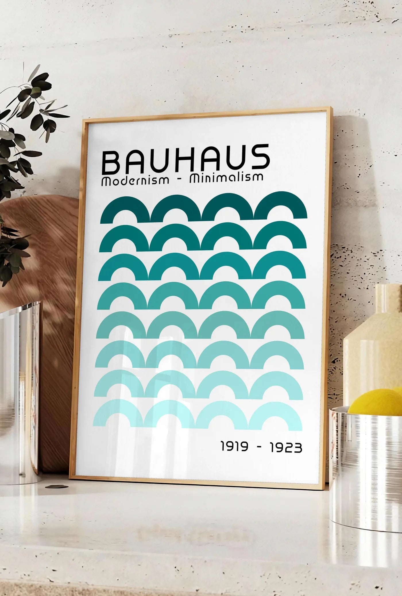 Affiche arches Brunes, posee sur un plan de travail de cuisine en pierre claire, entre une branche d'eucalyptus en vase et un bocal de citrons