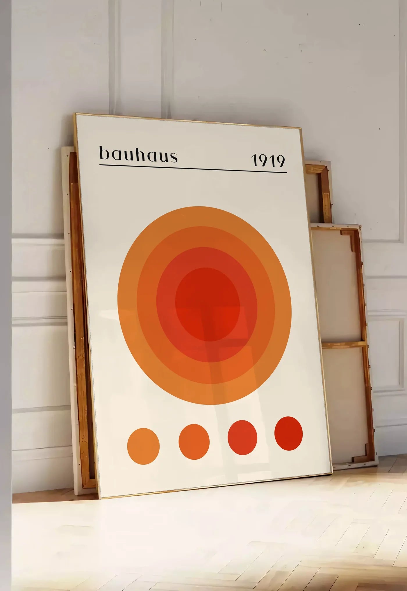 Tirage encadrable cercles Concentriques Chauds, posee au sol dans une entree lumineuse, contre un mur a panneaux blancs, a cote de chassis en bois empiles