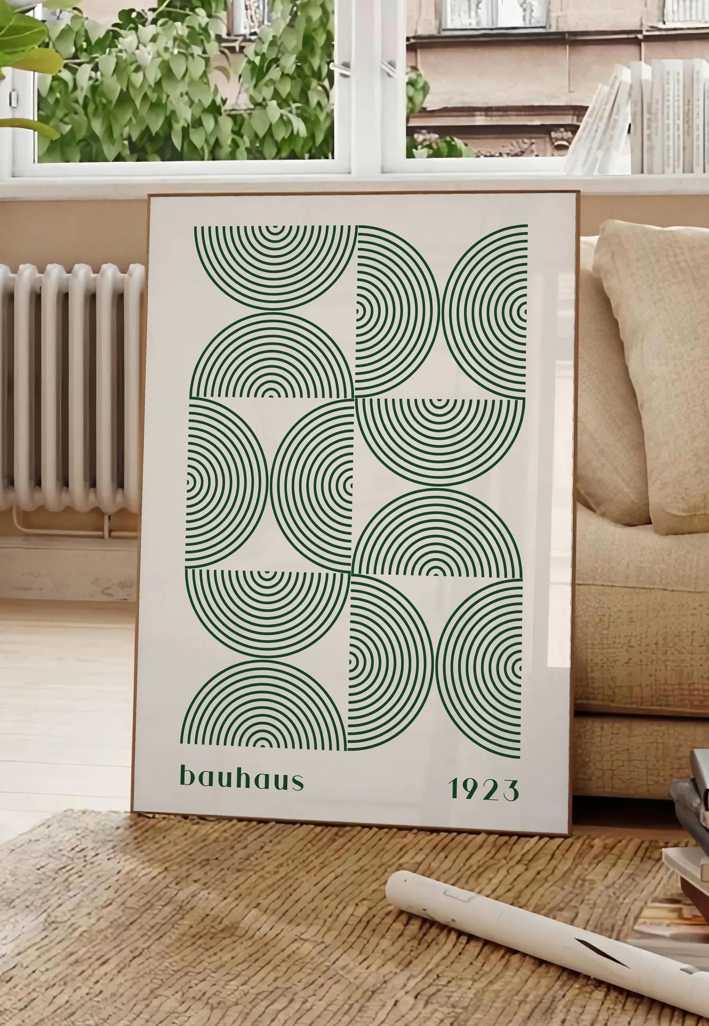 Poster arcs Concentriques Verts, posee au sol dans un salon parisien, devant une grande fenetre donnant sur un immeuble haussmannien, entre un ficus et un canape creme