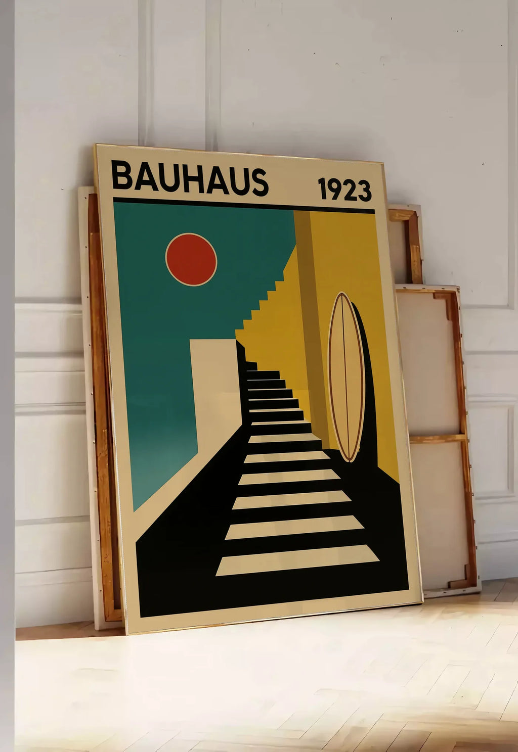 Tirage encadrable escalier et Surf, posee au sol dans une entree lumineuse, contre un mur a panneaux blancs, a cote de chassis en bois empiles