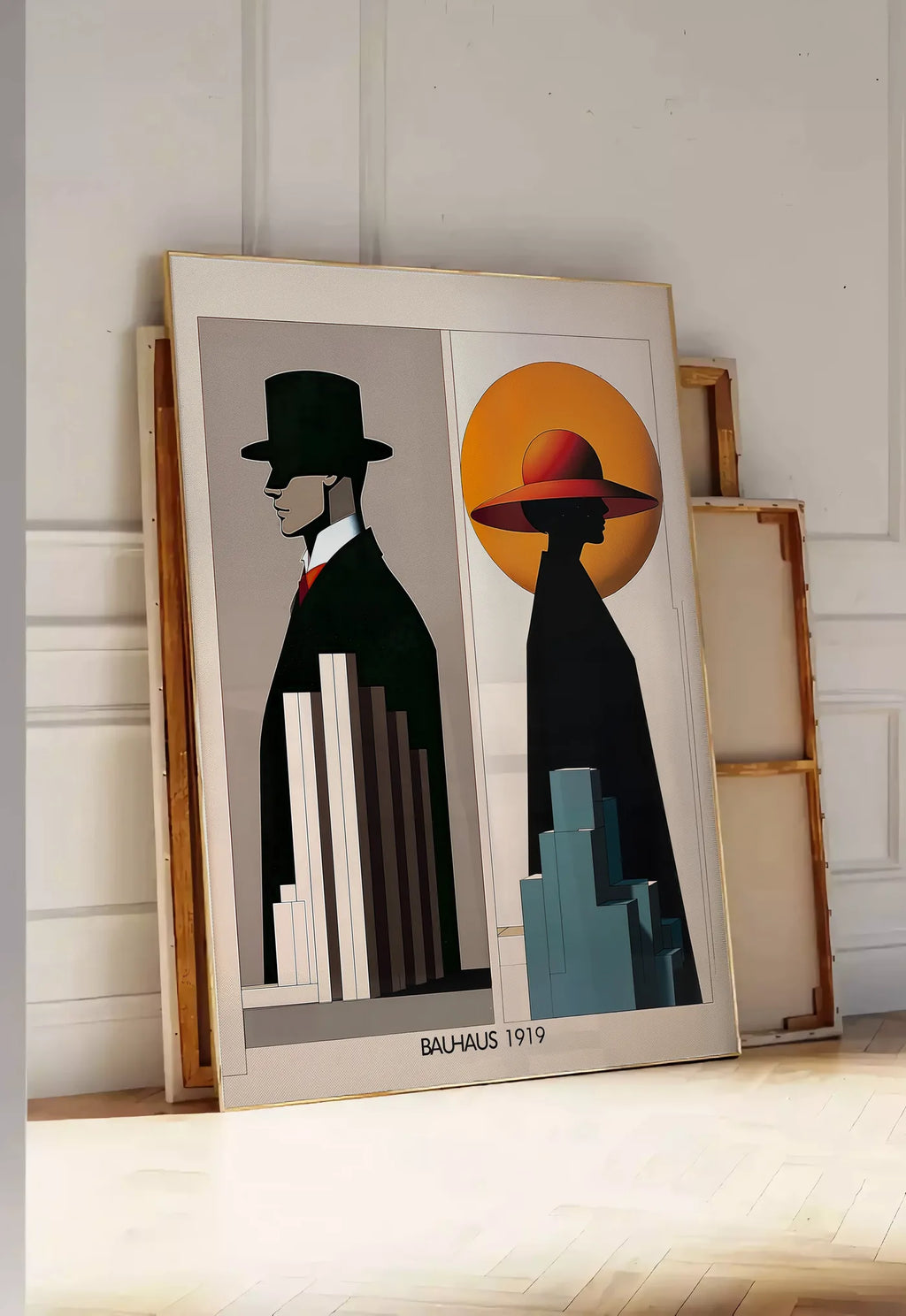 Tirage encadrable figures Art Deco, posee au sol dans une entree lumineuse, contre un mur a panneaux blancs, a cote de chassis en bois empiles