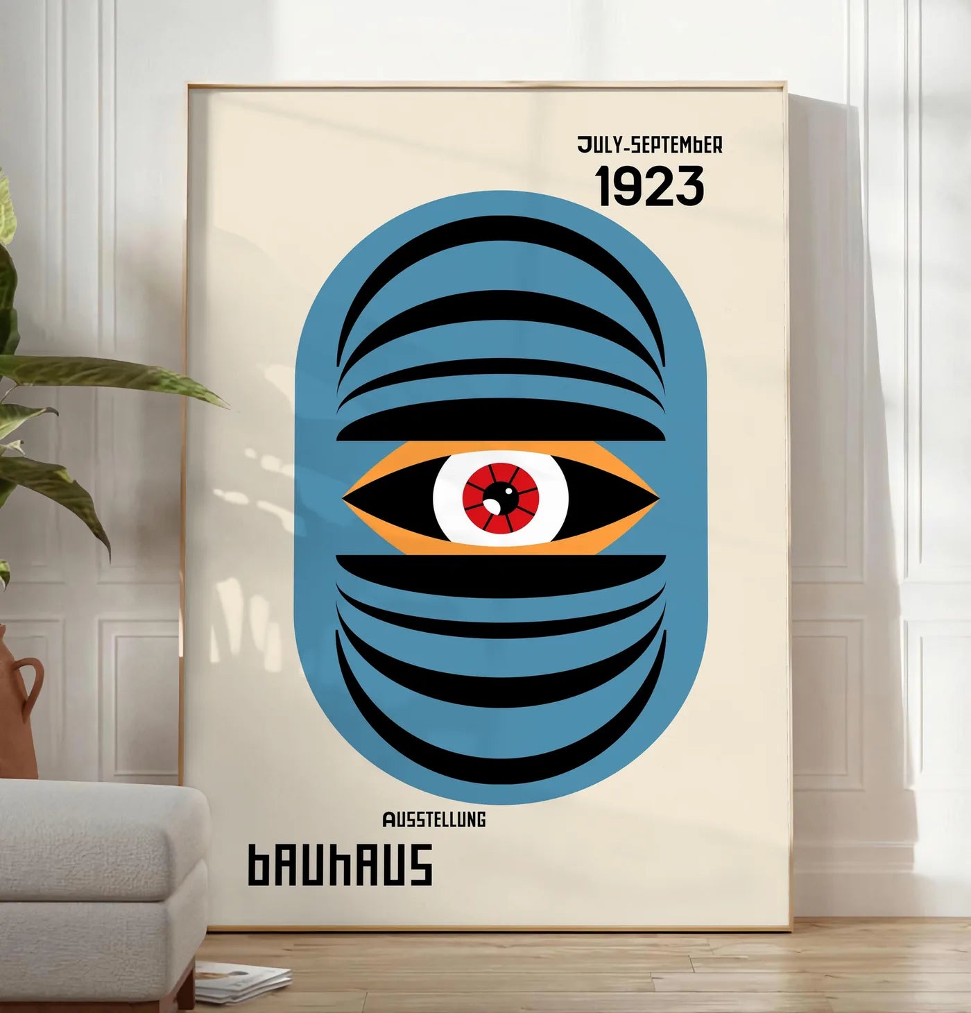 Reproduction oeil Bleu Surreel, posee au sol dans un salon minimaliste clair, a cote d'un canape beige et d'une plante verte, sur un parquet clair