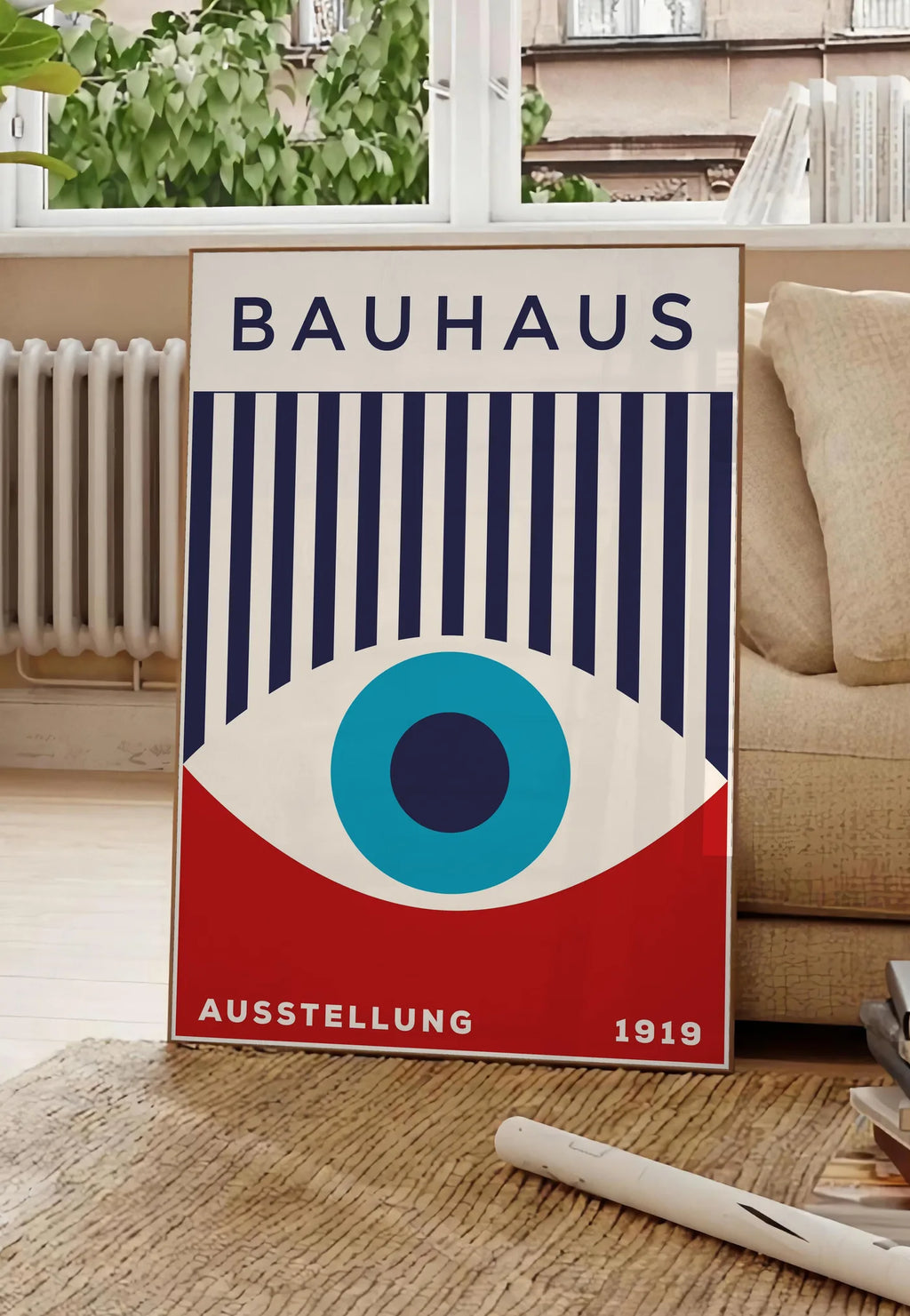 Poster oeil Turquoise, posee au sol dans un salon parisien, devant une grande fenetre donnant sur un immeuble haussmannien, entre un ficus et un canape creme