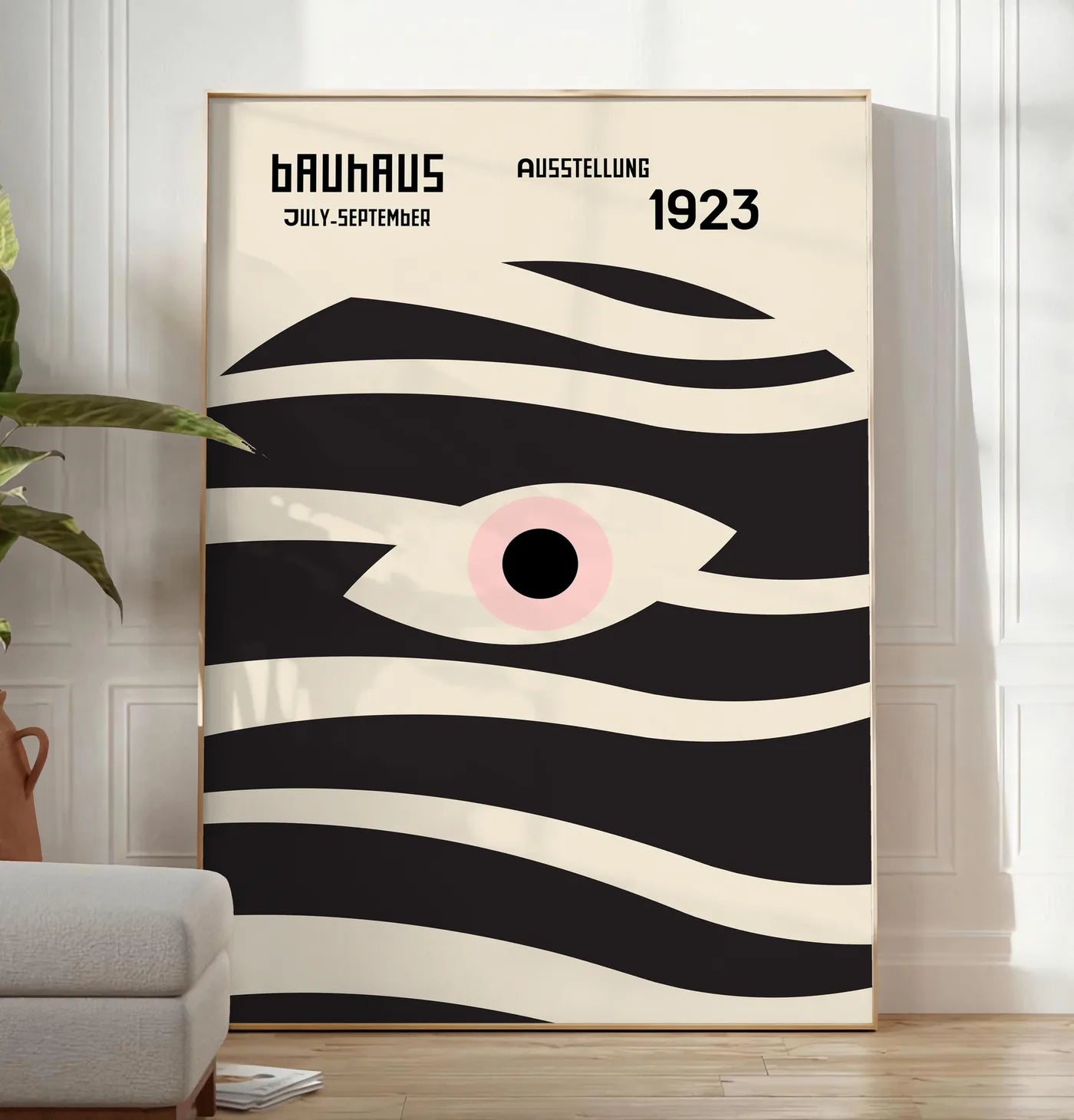 Reproduction oeil et Vagues, posee au sol dans un salon minimaliste clair, a cote d'un canape beige et d'une plante verte, sur un parquet clair