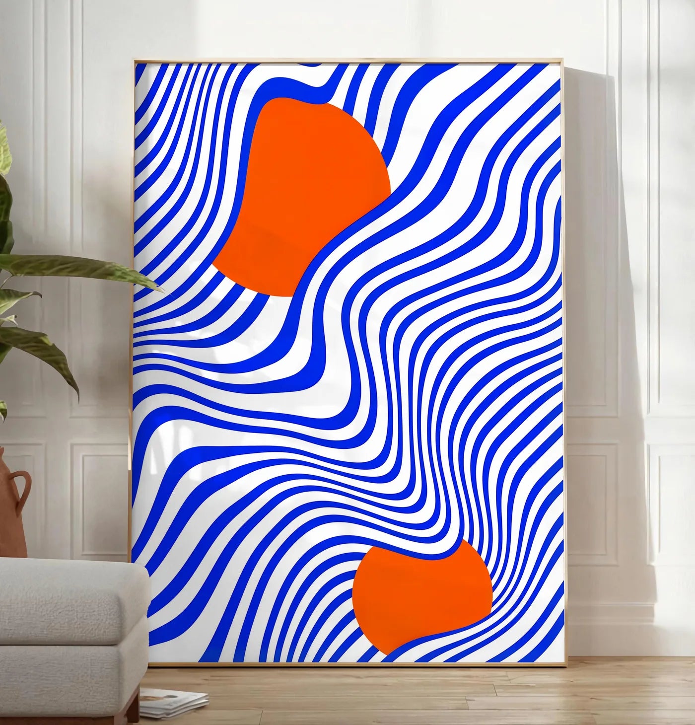 Reproduction op Art Bleu et Orange, posee au sol dans un salon minimaliste clair, a cote d'un canape beige et d'une plante verte, sur un parquet clair