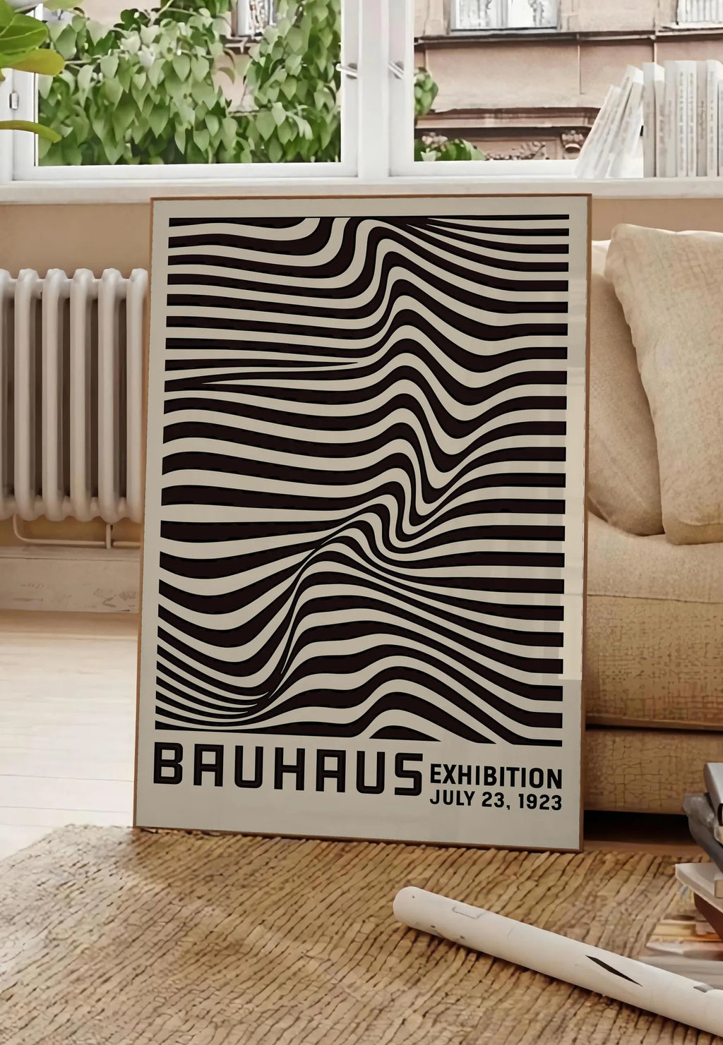 Poster op Art Vagues Noires, posee au sol dans un salon parisien, devant une grande fenetre donnant sur un immeuble haussmannien, entre un ficus et un canape creme
