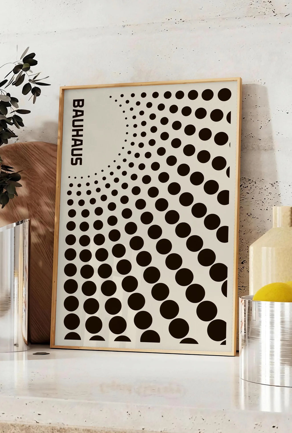 Affiche degrade de Points, posee sur un plan de travail de cuisine en pierre claire, entre une branche d'eucalyptus en vase et un bocal de citrons