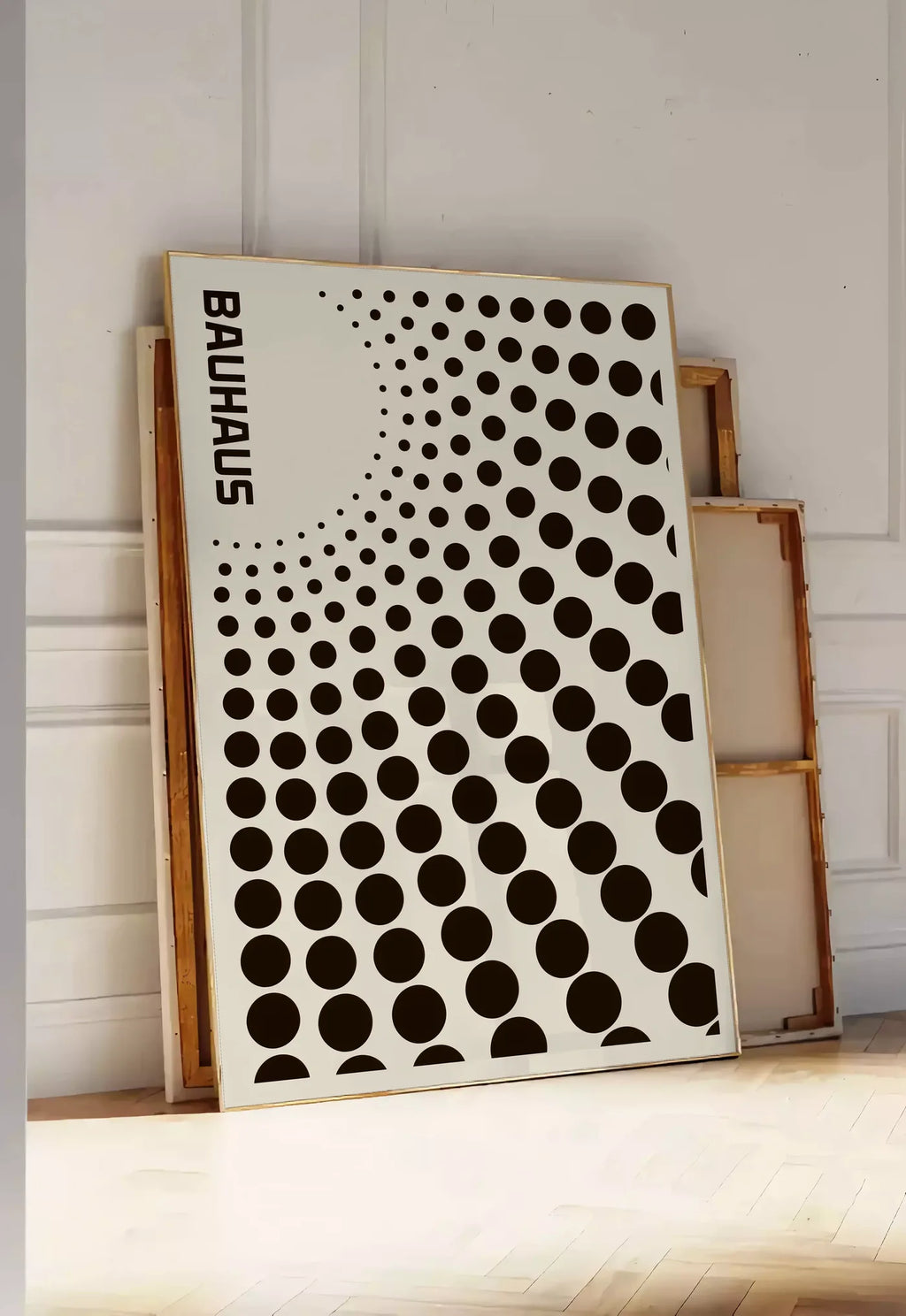 Tirage encadrable degrade de Points, posee au sol dans une entree lumineuse, contre un mur a panneaux blancs, a cote de chassis en bois empiles