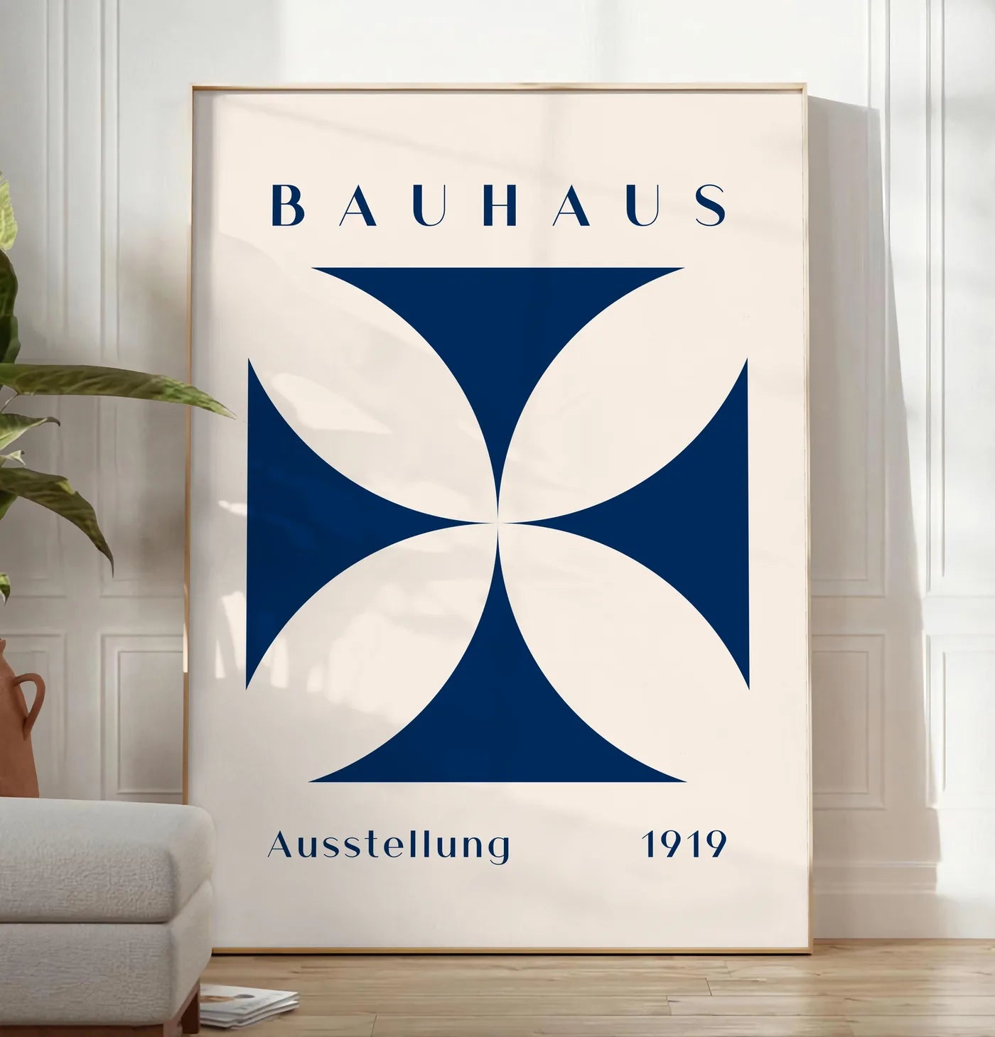 Reproduction quatre-Petales Bleus, posee au sol dans un salon minimaliste clair, a cote d'un canape beige et d'une plante verte, sur un parquet clair