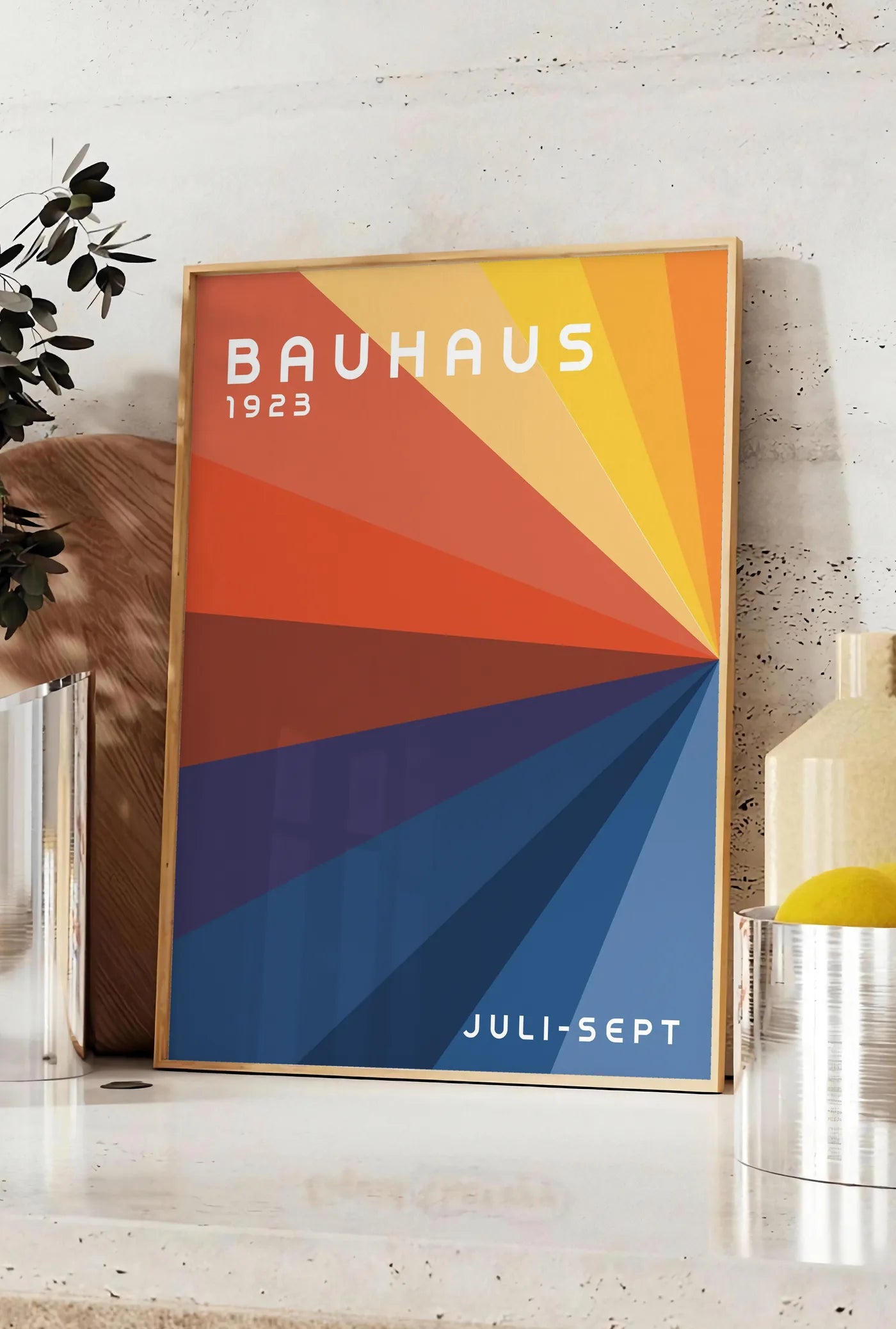 Affiche roue de Couleurs, posee sur un plan de travail de cuisine en pierre claire, entre une branche d'eucalyptus en vase et un bocal de citrons