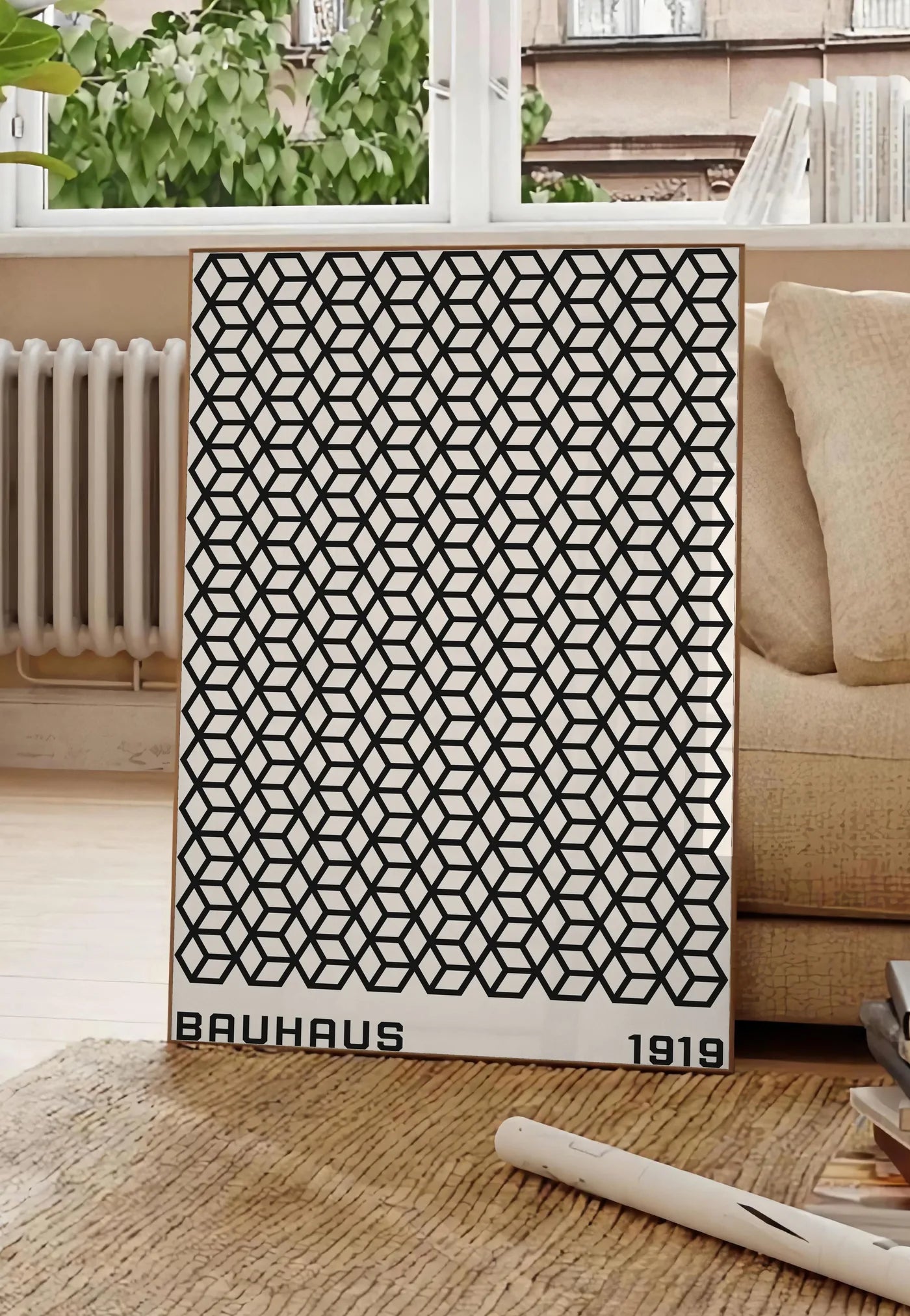 Poster treillis de Cubes, posee au sol dans un salon parisien, devant une grande fenetre donnant sur un immeuble haussmannien, entre un ficus et un canape creme