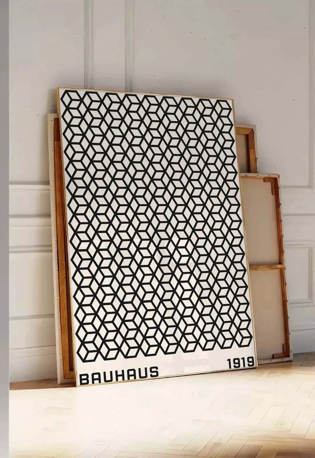 Tirage encadrable treillis de Cubes, posee au sol dans une entree lumineuse, contre un mur a panneaux blancs, a cote de chassis en bois empiles