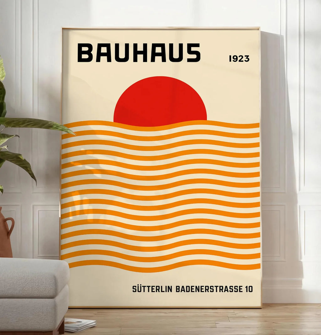 Reproduction vagues Orange et Soleil, posee au sol dans un salon minimaliste clair, a cote d'un canape beige et d'une plante verte, sur un parquet clair