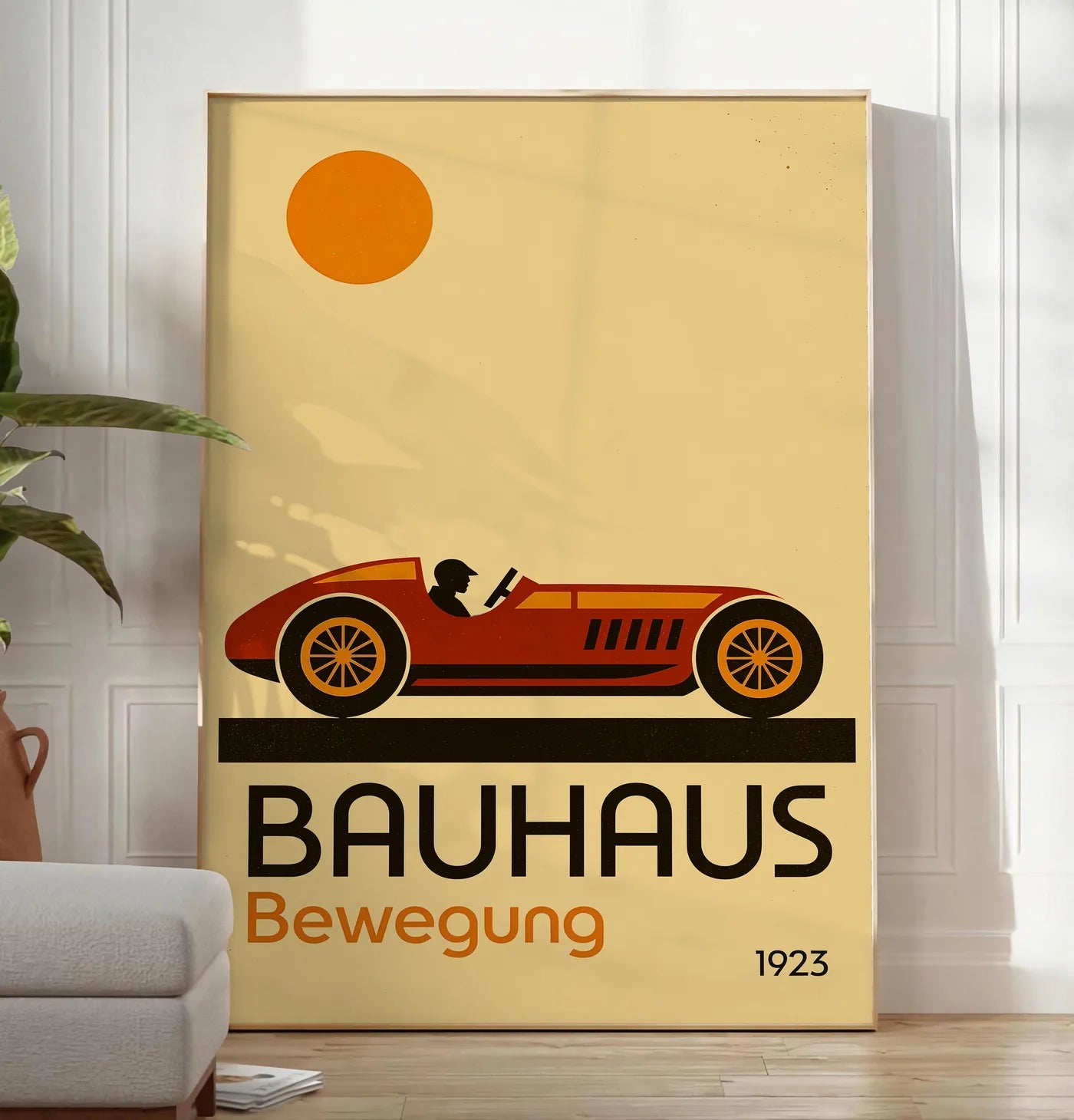 Reproduction voiture de Course, posee au sol dans un salon minimaliste clair, a cote d'un canape beige et d'une plante verte, sur un parquet clair