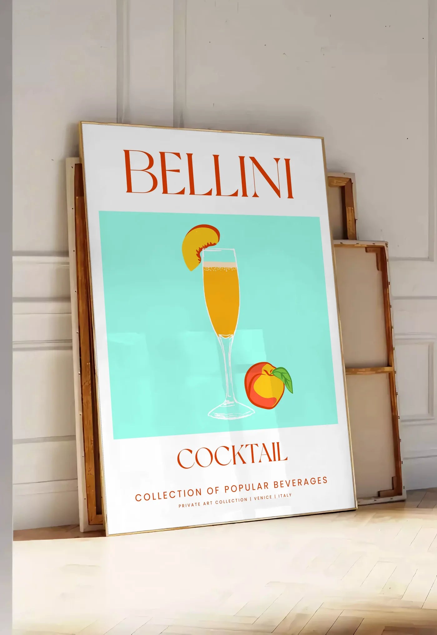 Tirage encadrable affiche cocktail Bellini, posee au sol dans une entree lumineuse, contre un mur a panneaux blancs, a cote de chassis en bois empiles