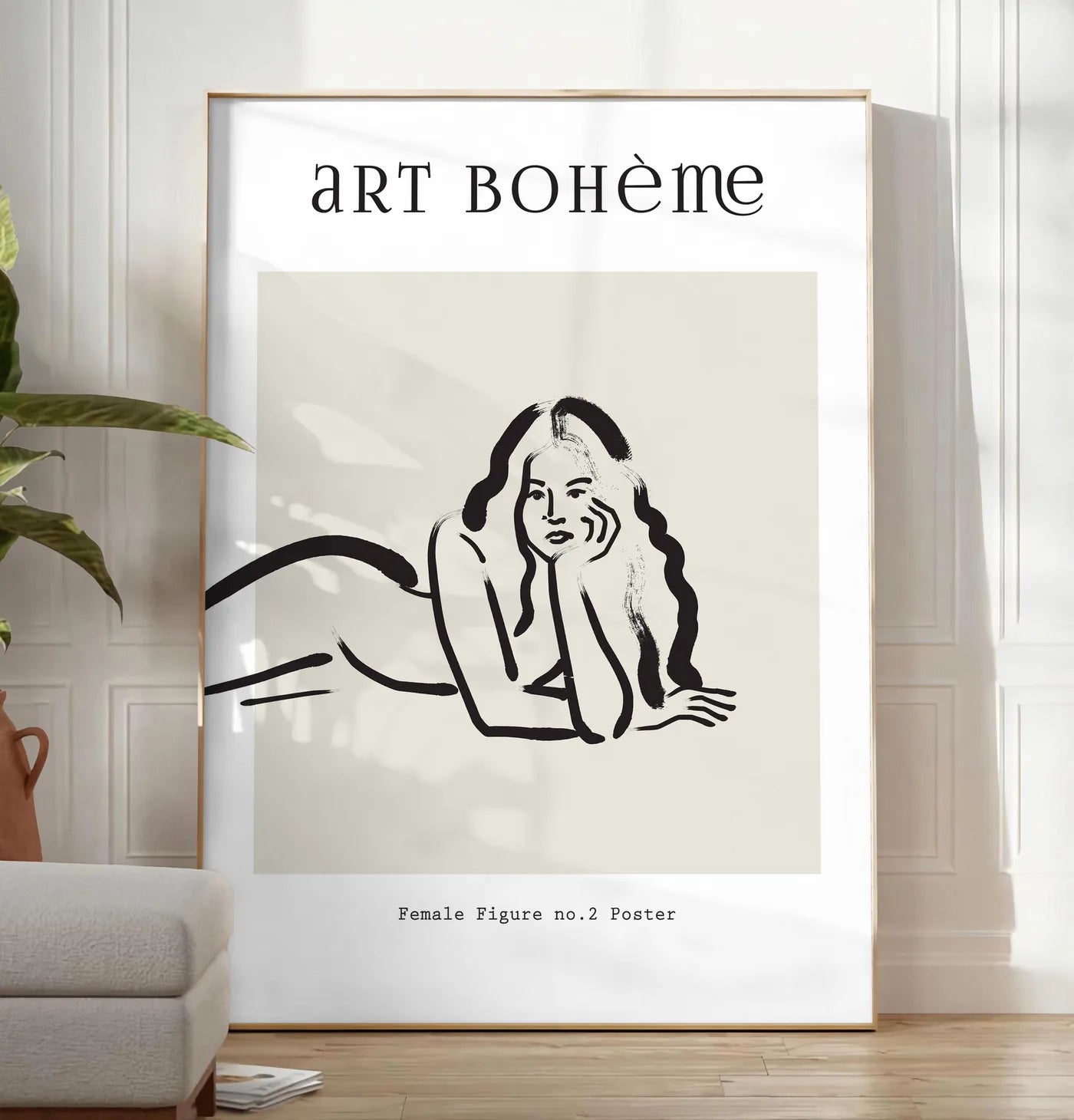 Reproduction femme allongee au trait de pinceau noir sur creme, posee au sol dans un salon minimaliste clair, a cote d'un canape beige et d'une plante verte, sur un parquet clair