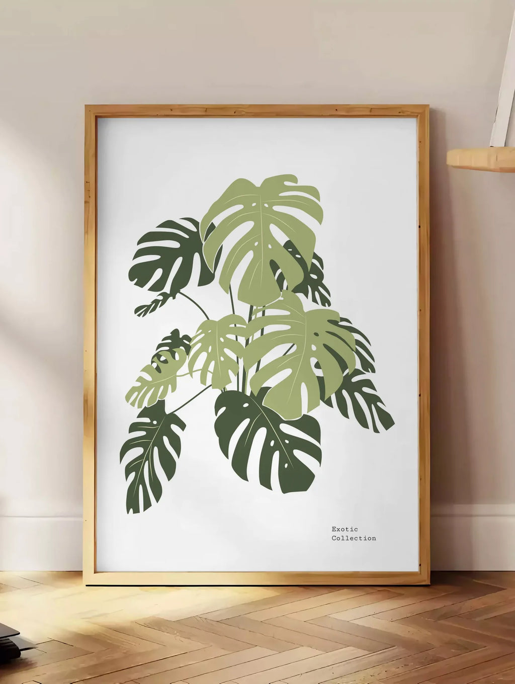 Estampe affiche monstera botanique, posee au sol dans un coin salon, sur un parquet a chevrons, pres d'une table d'appoint en chene chargee de livres