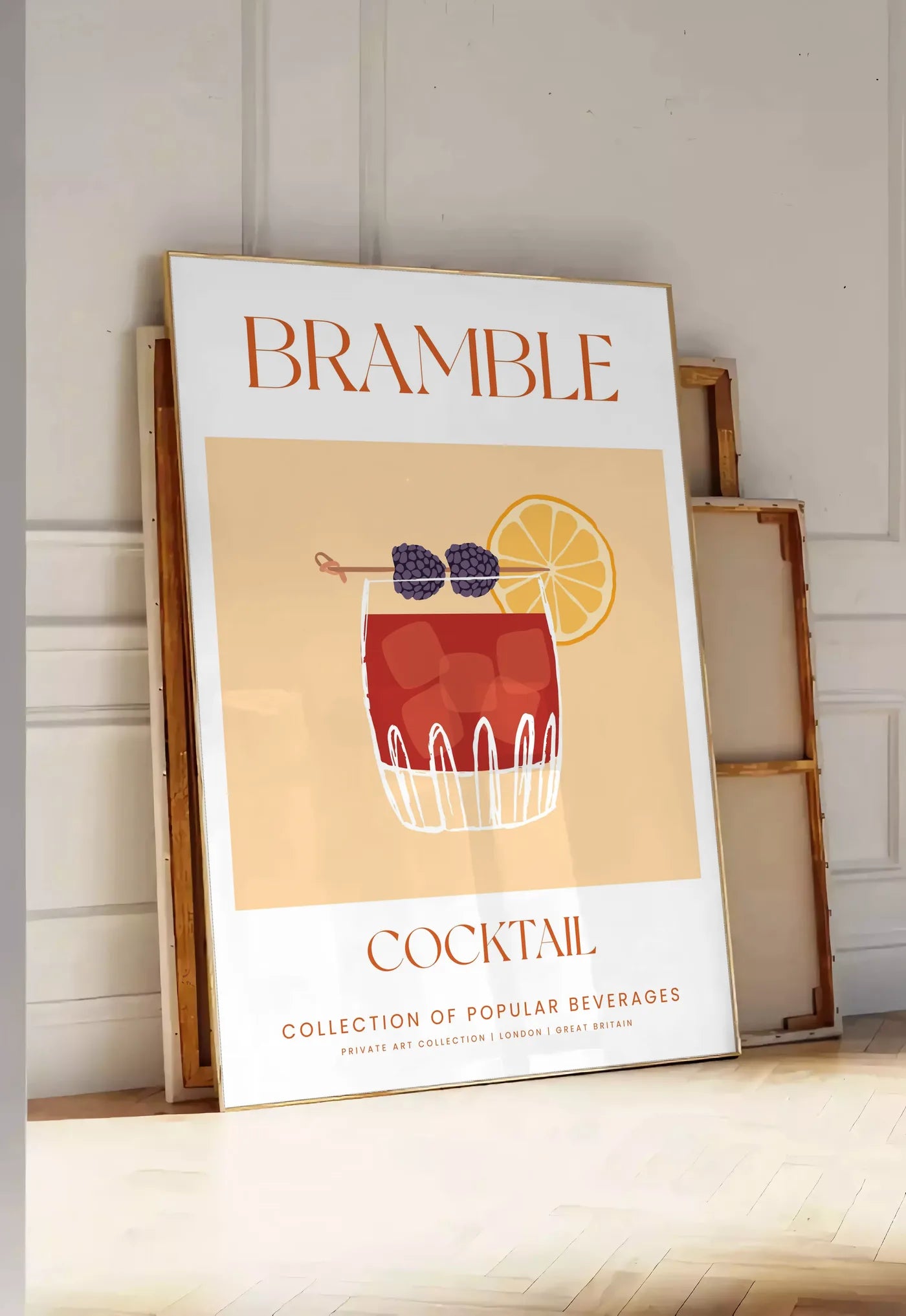 Tirage encadrable affiche cocktail Bramble, posee au sol dans une entree lumineuse, contre un mur a panneaux blancs, a cote de chassis en bois empiles