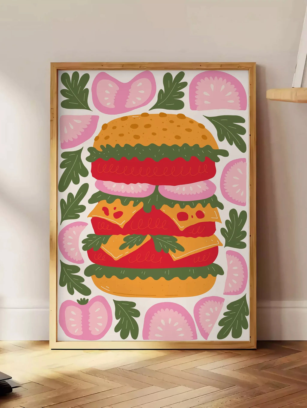Estampe affiche cuisine burger, posee au sol dans un coin salon, sur un parquet a chevrons, pres d'une table d'appoint en chene chargee de livres