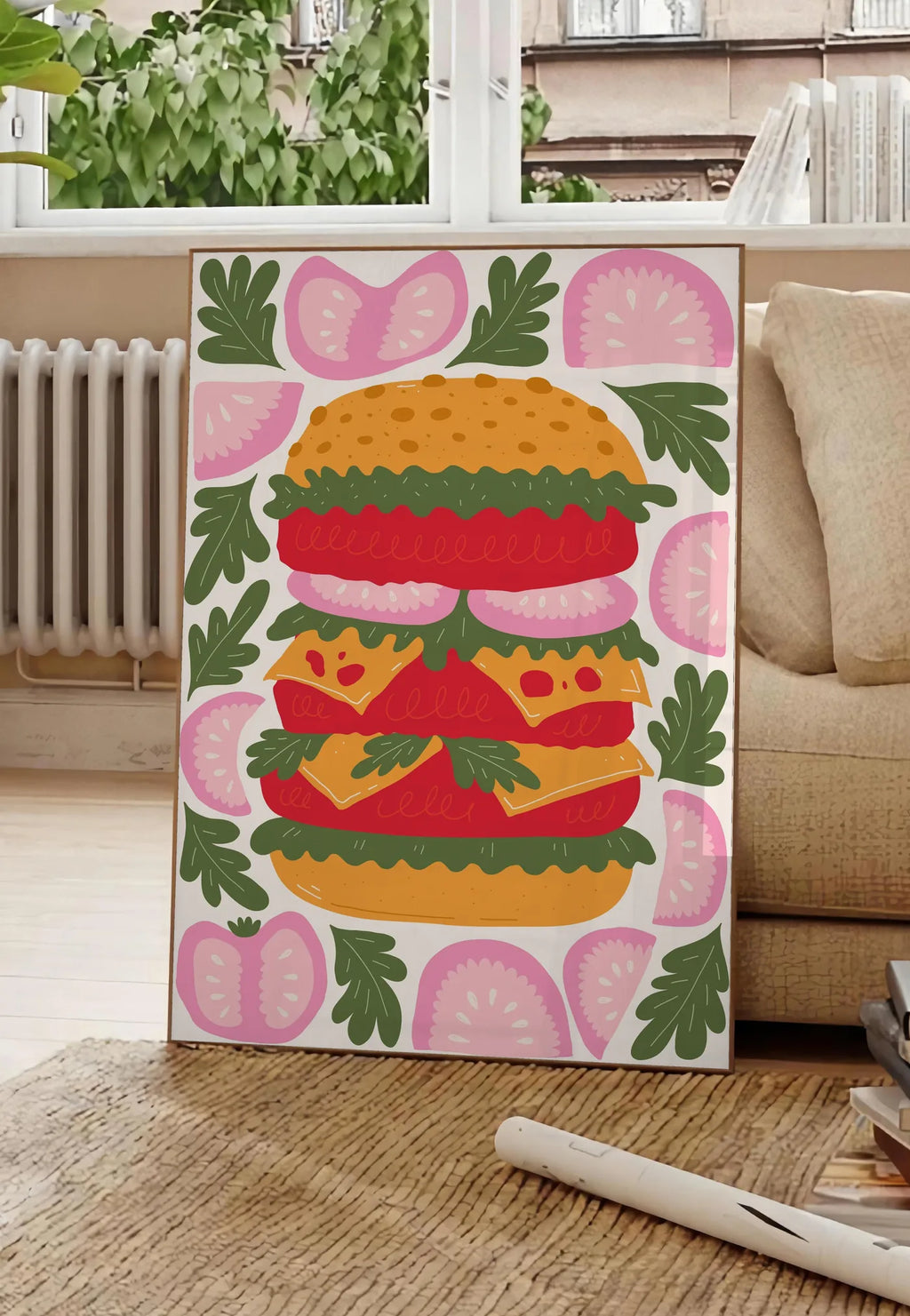 Poster affiche cuisine burger, posee au sol dans un salon parisien, devant une grande fenetre donnant sur un immeuble haussmannien, entre un ficus et un canape creme