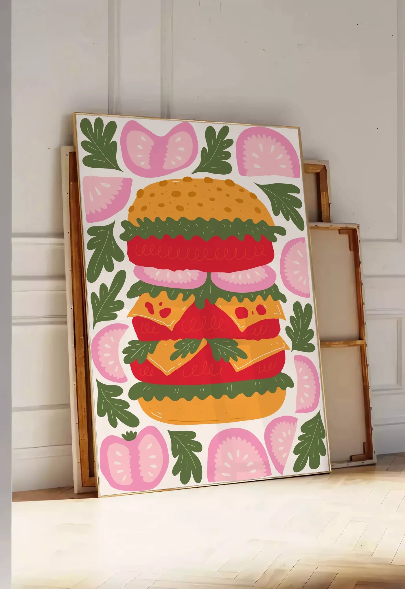 Tirage encadrable affiche cuisine burger, posee au sol dans une entree lumineuse, contre un mur a panneaux blancs, a cote de chassis en bois empiles