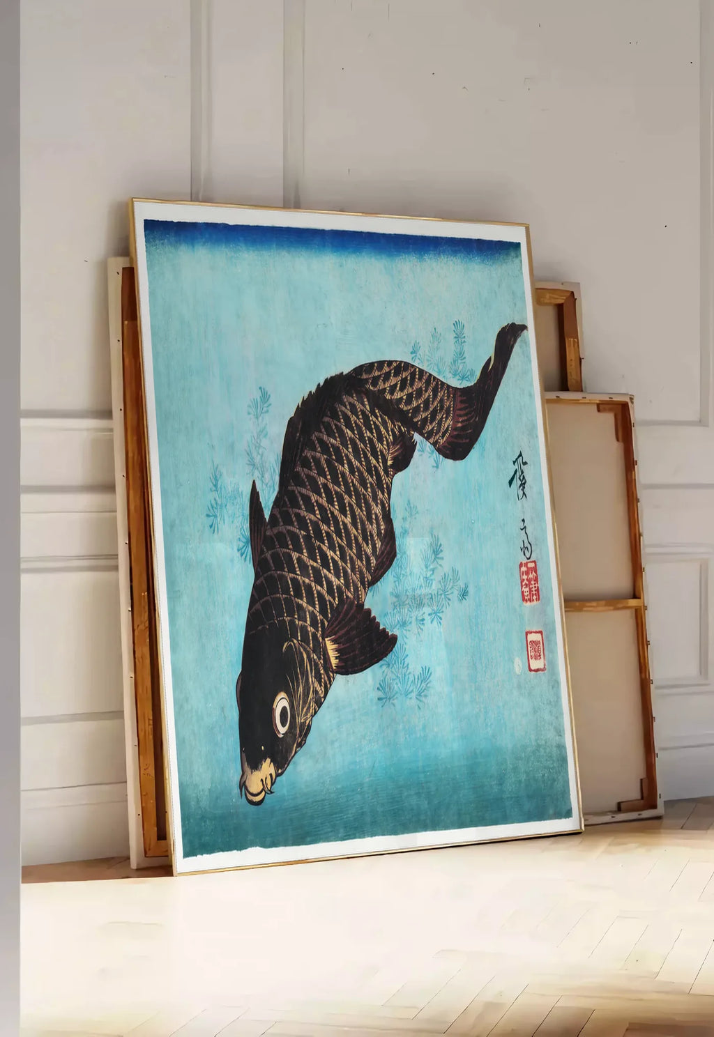 Tirage encadrable affiche carpe noire sur fond bleu art japonais, posee au sol dans une entree lumineuse, contre un mur a panneaux blancs, a cote de chassis en bois empiles