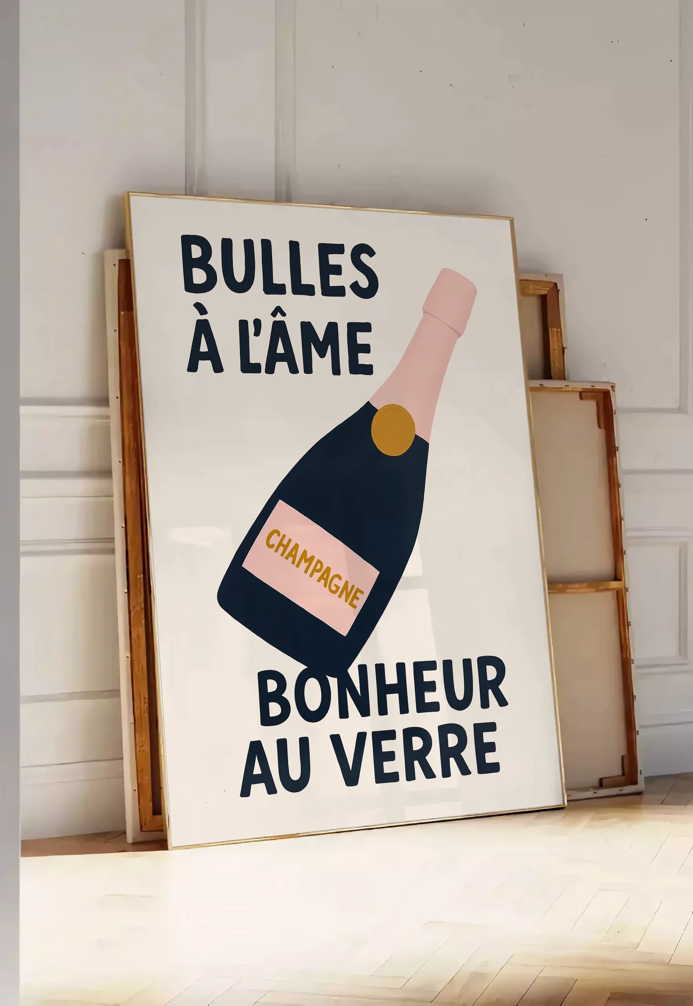 Tirage encadrable affiche champagne Bulles a l'ame, posee au sol dans une entree lumineuse, contre un mur a panneaux blancs, a cote de chassis en bois empiles