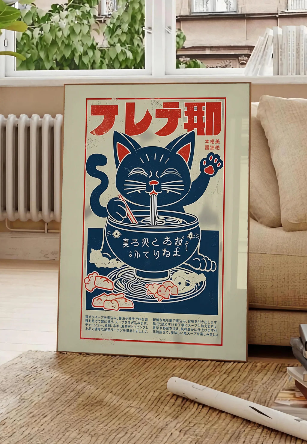 Poster affiche chat ramen enseigne, posee au sol dans un salon parisien, devant une grande fenetre donnant sur un immeuble haussmannien, entre un ficus et un canape creme