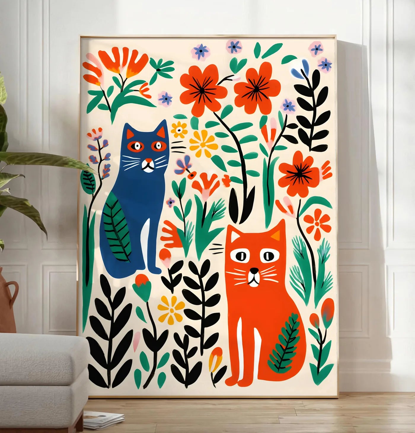 Reproduction affiche chats art naif, posee au sol dans un salon minimaliste clair, a cote d'un canape beige et d'une plante verte, sur un parquet clair