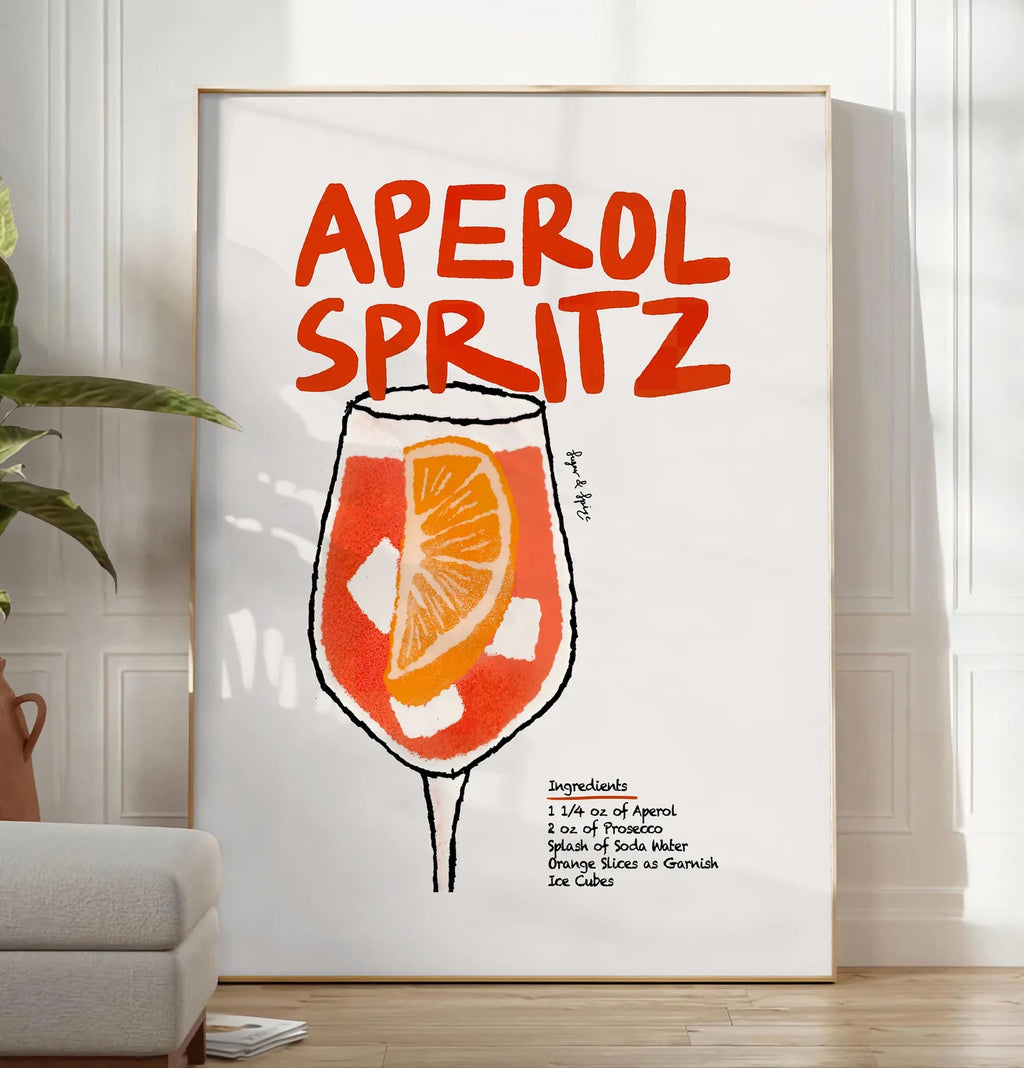 Reproduction verre d'Aperol Spritz, posee au sol dans un salon minimaliste clair, a cote d'un canape beige et d'une plante verte, sur un parquet clair