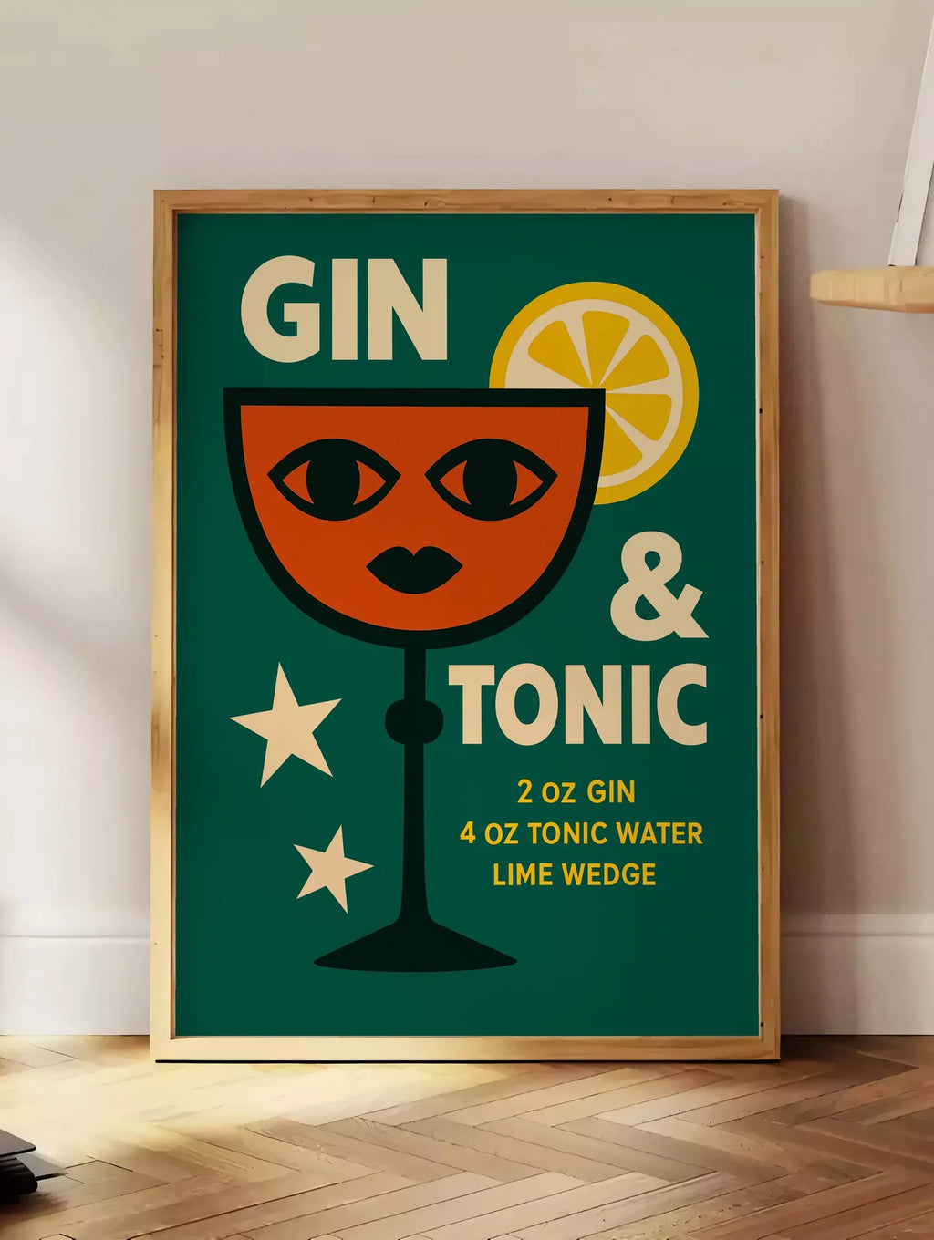 Estampe affiche gin tonic pop-art, posee au sol dans un coin salon, sur un parquet a chevrons, pres d'une table d'appoint en chene chargee de livres