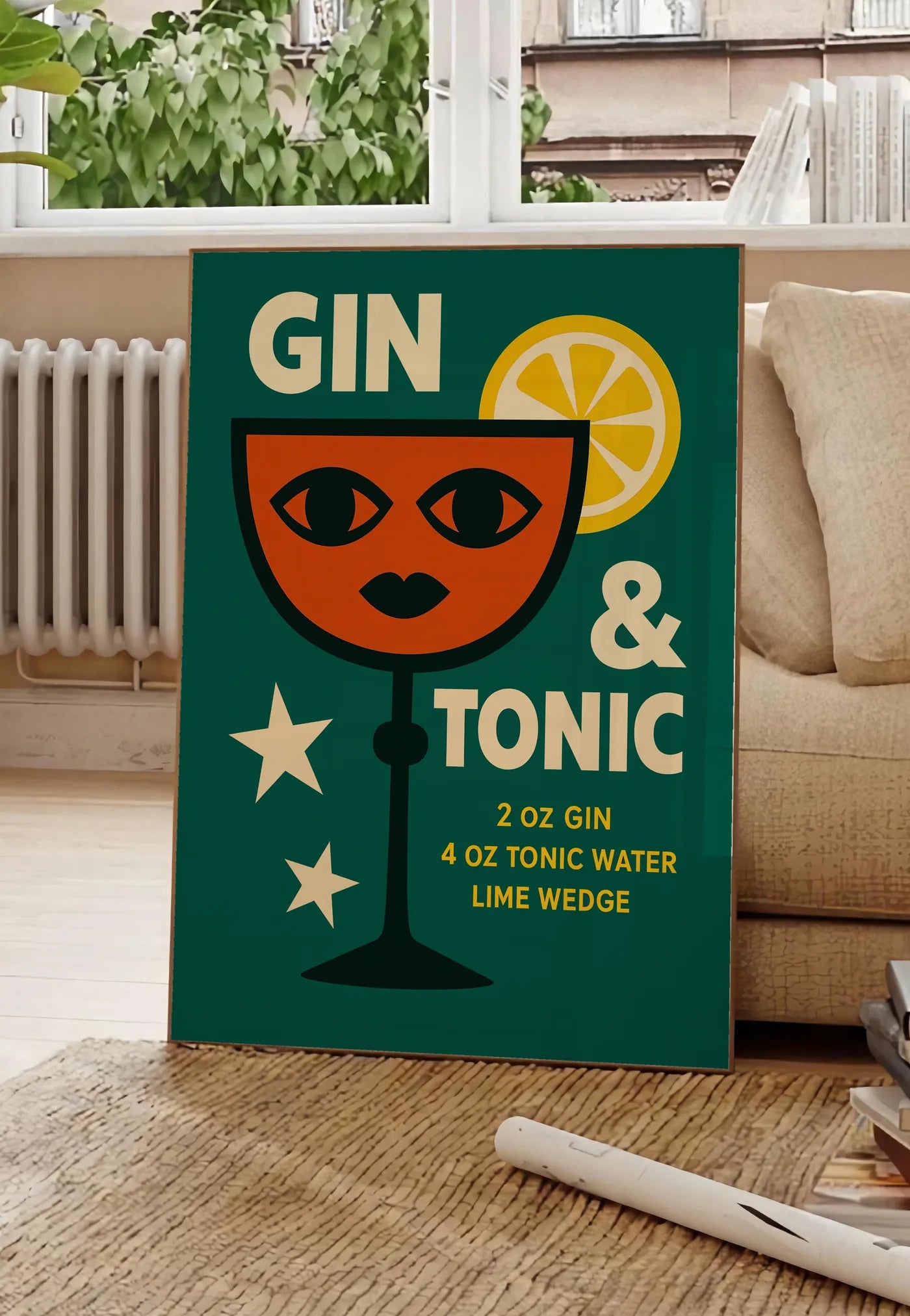 Poster affiche gin tonic pop-art, posee au sol dans un salon parisien, devant une grande fenetre donnant sur un immeuble haussmannien, entre un ficus et un canape creme