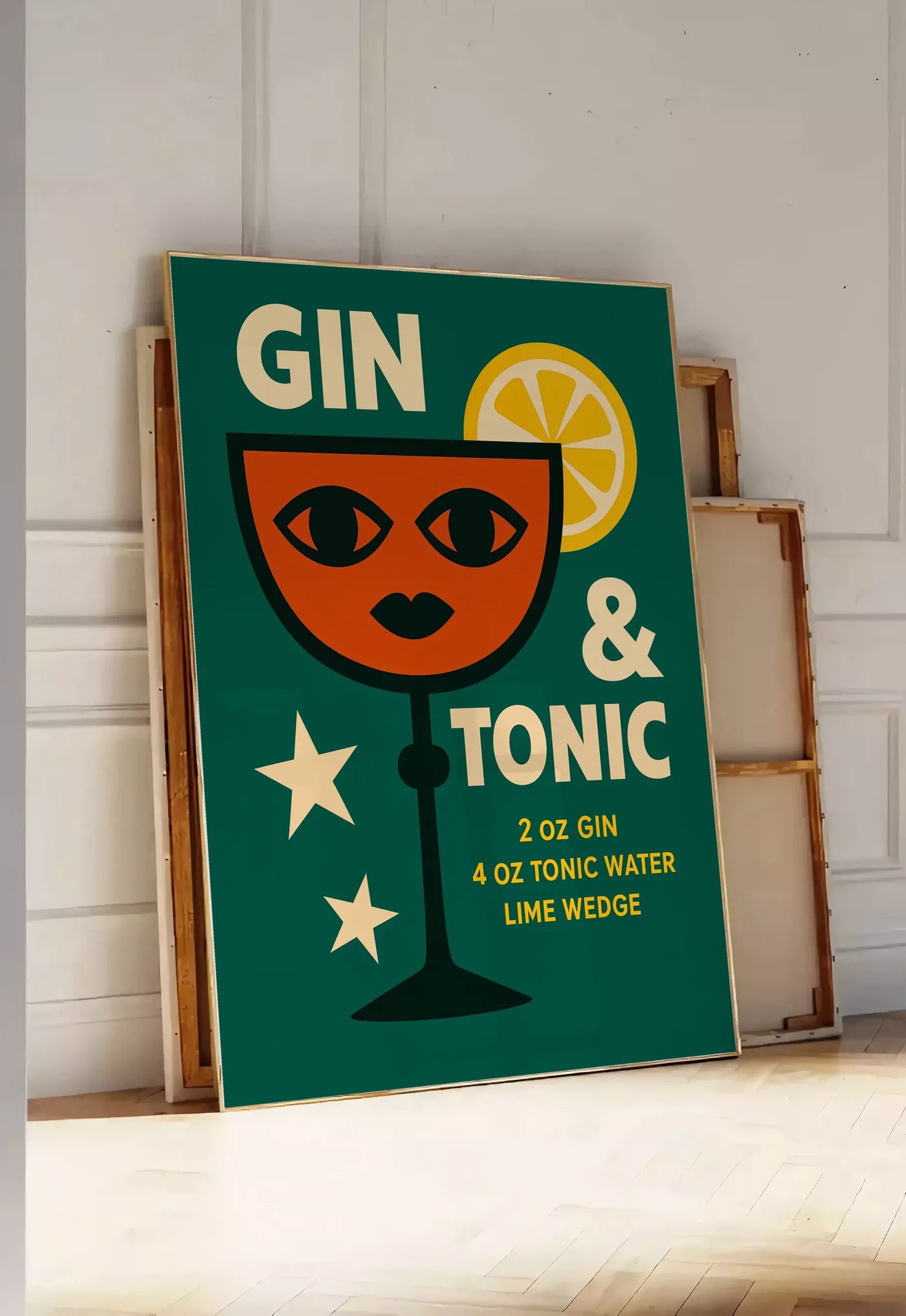 Tirage encadrable affiche gin tonic pop-art, posee au sol dans une entree lumineuse, contre un mur a panneaux blancs, a cote de chassis en bois empiles