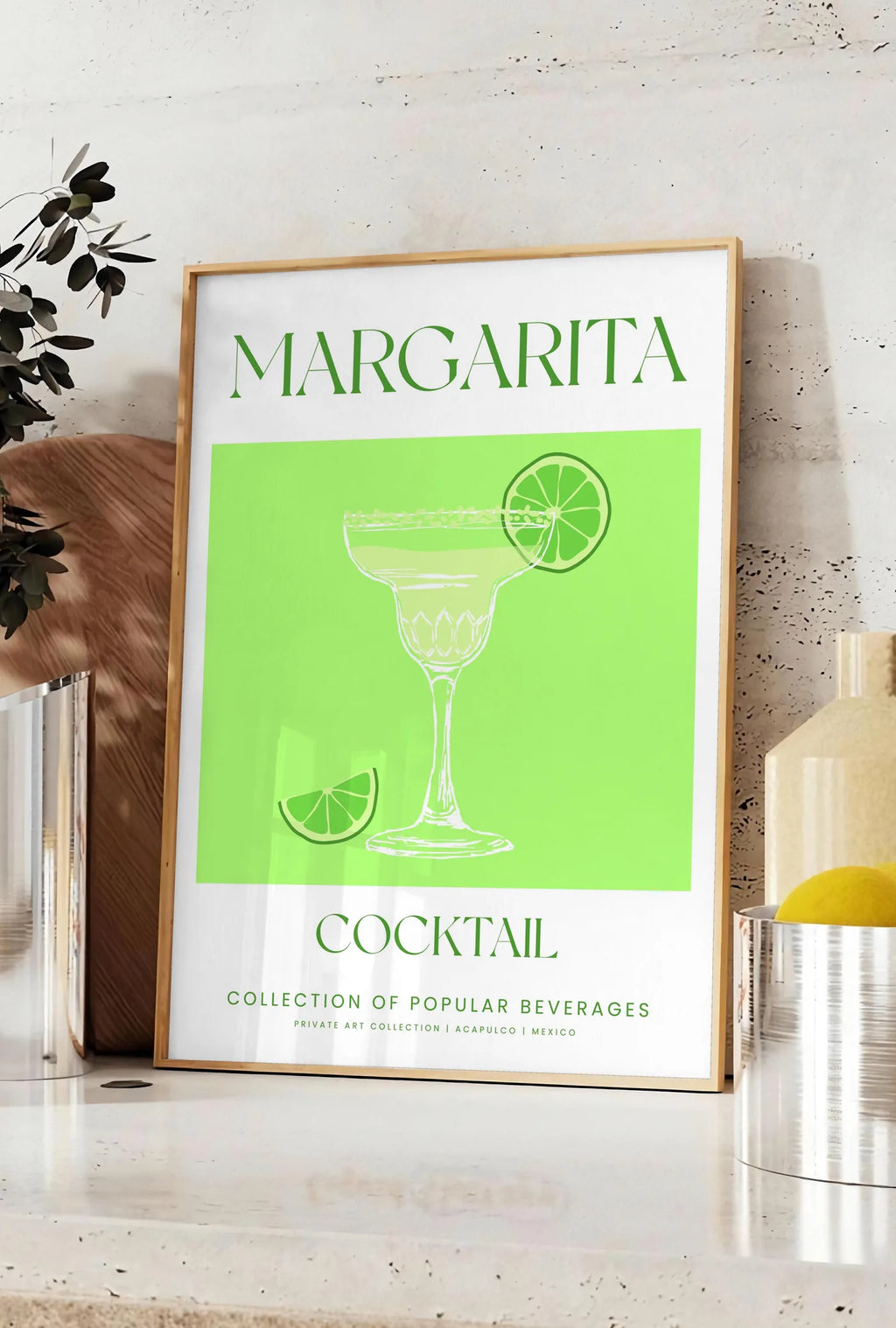 Affiche affiche margarita minimaliste, posee sur un plan de travail de cuisine en pierre claire, entre une branche d'eucalyptus en vase et un bocal de citrons