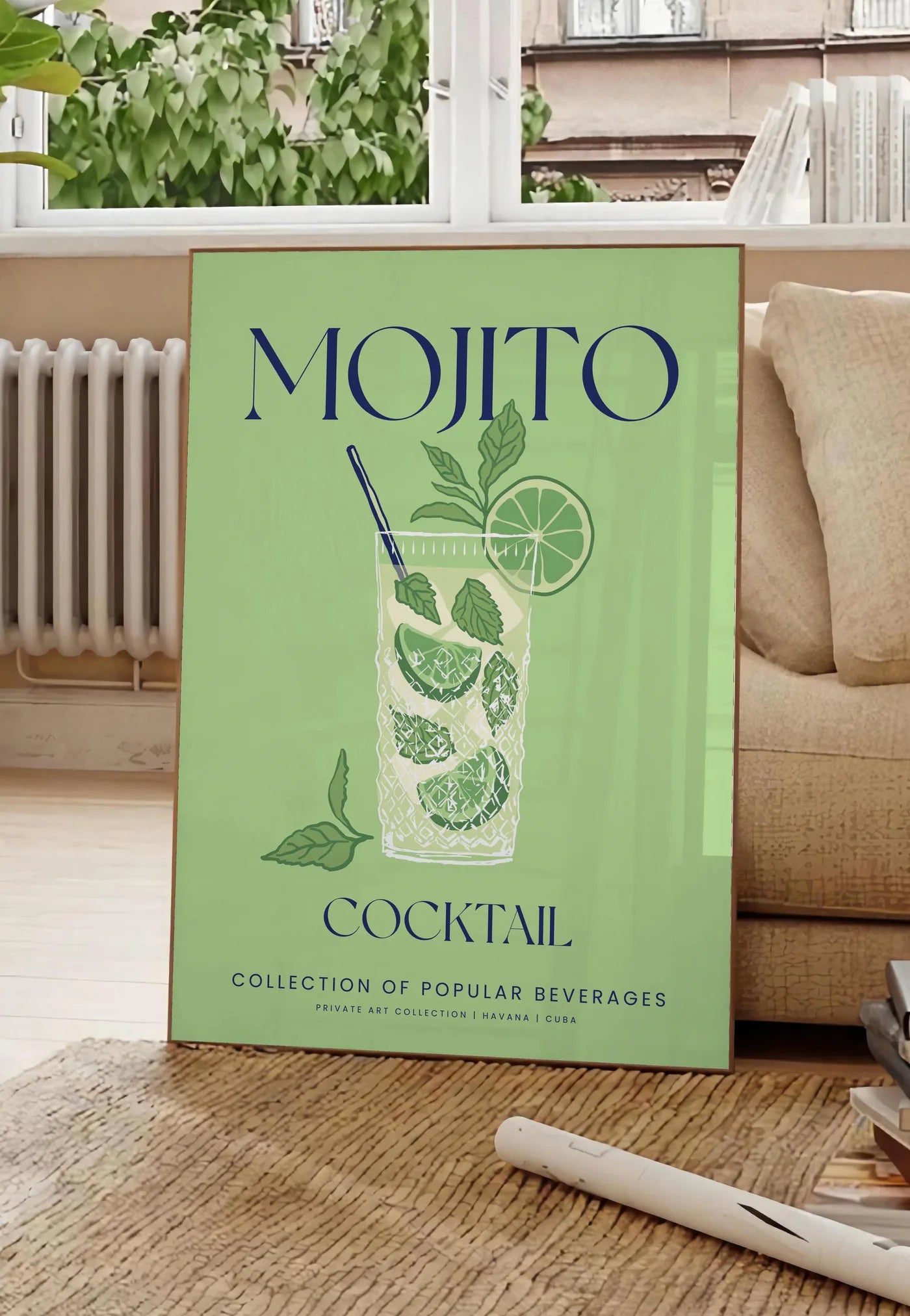 Poster affiche mojito minimaliste, posee au sol dans un salon parisien, devant une grande fenetre donnant sur un immeuble haussmannien, entre un ficus et un canape creme