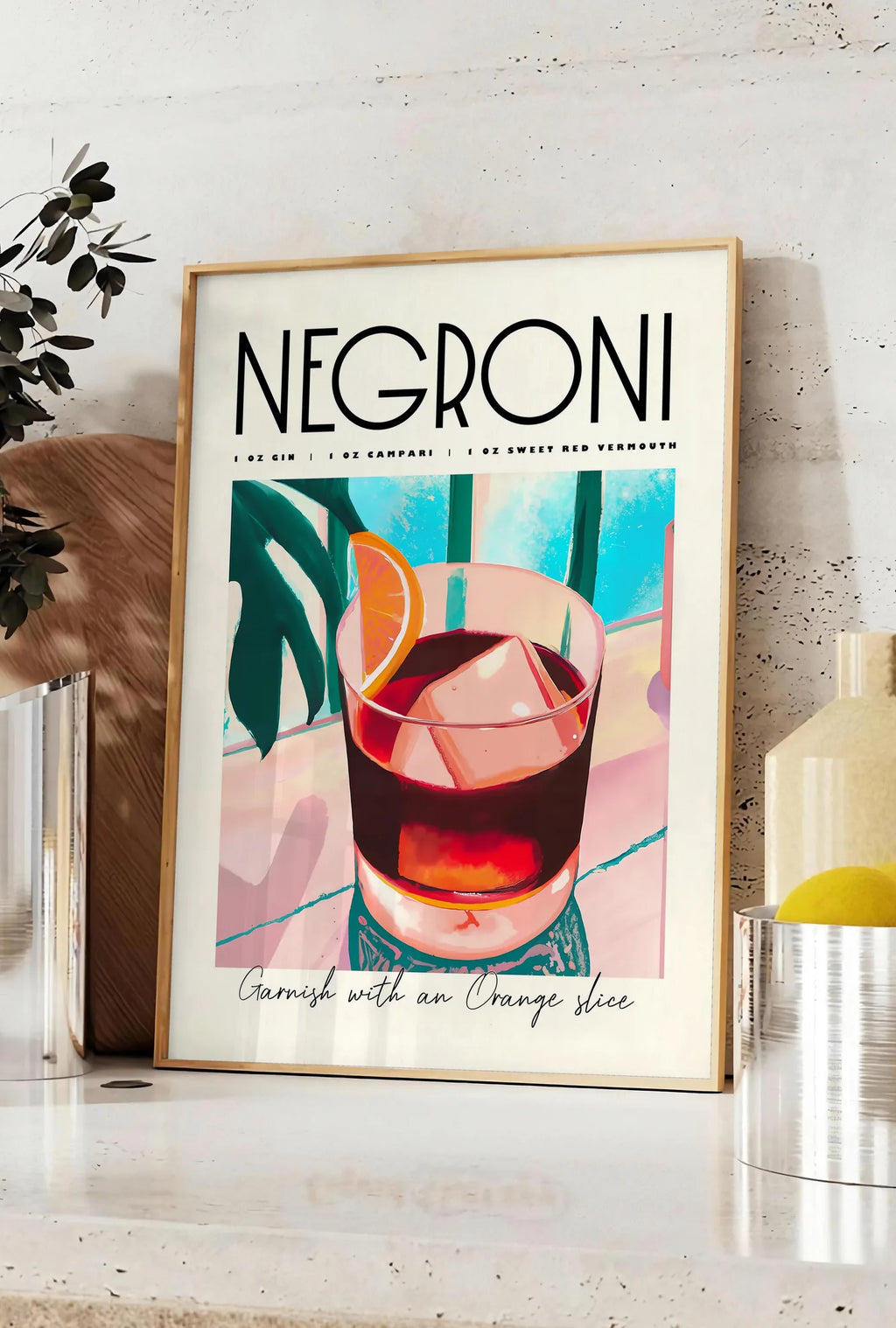 Affiche verre de Negroni avec cube de glace massif, posee sur un plan de travail de cuisine en pierre claire, entre une branche d'eucalyptus en vase et un bocal de citrons