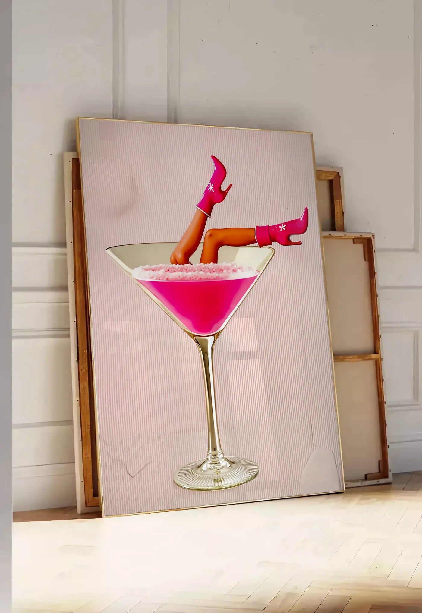 Tirage encadrable affiche cocktail rose kitsch, posee au sol dans une entree lumineuse, contre un mur a panneaux blancs, a cote de chassis en bois empiles