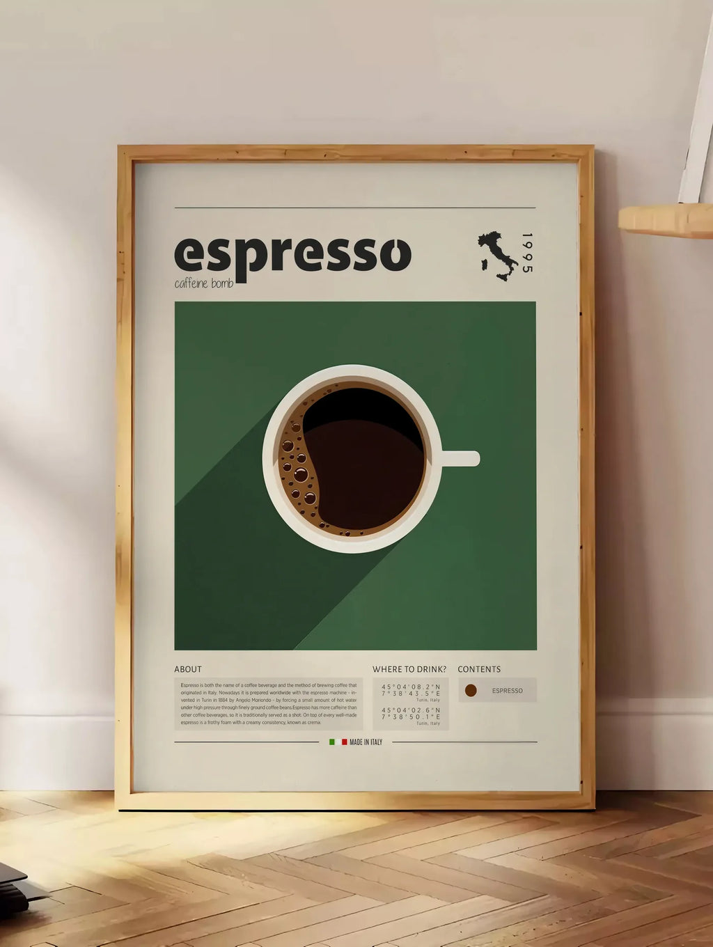 Estampe tasse d'espresso vue de dessus sur fond vert, posee au sol dans un coin salon, sur un parquet a chevrons, pres d'une table d'appoint en chene chargee de livres