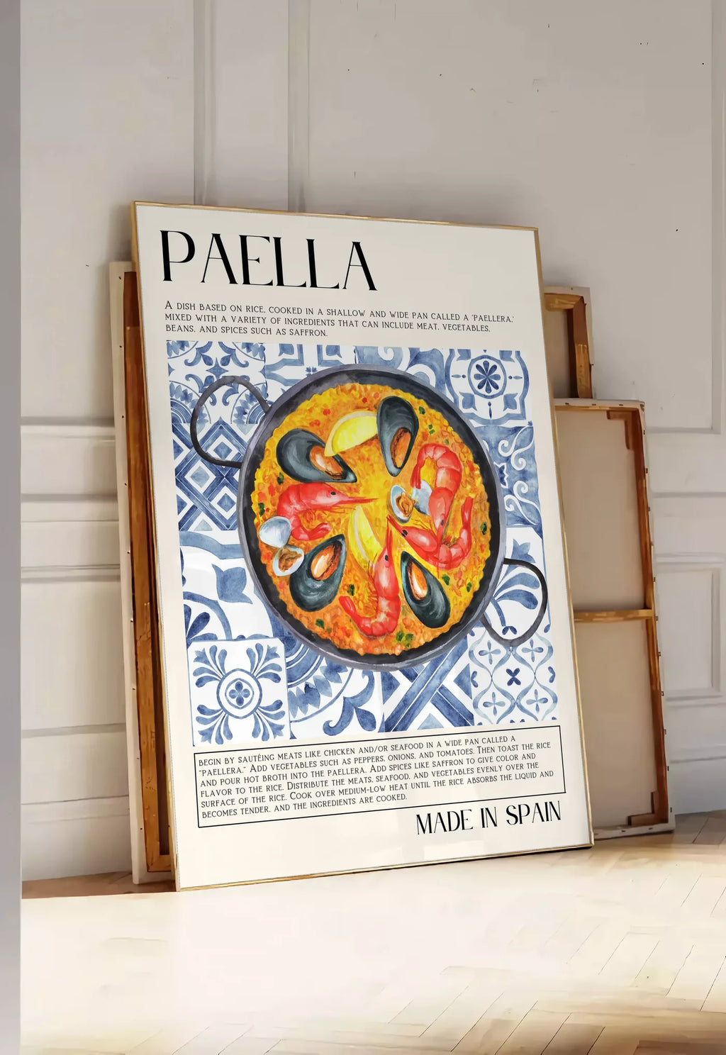 Tirage encadrable affiche paella aquarelle, posee au sol dans une entree lumineuse, contre un mur a panneaux blancs, a cote de chassis en bois empiles