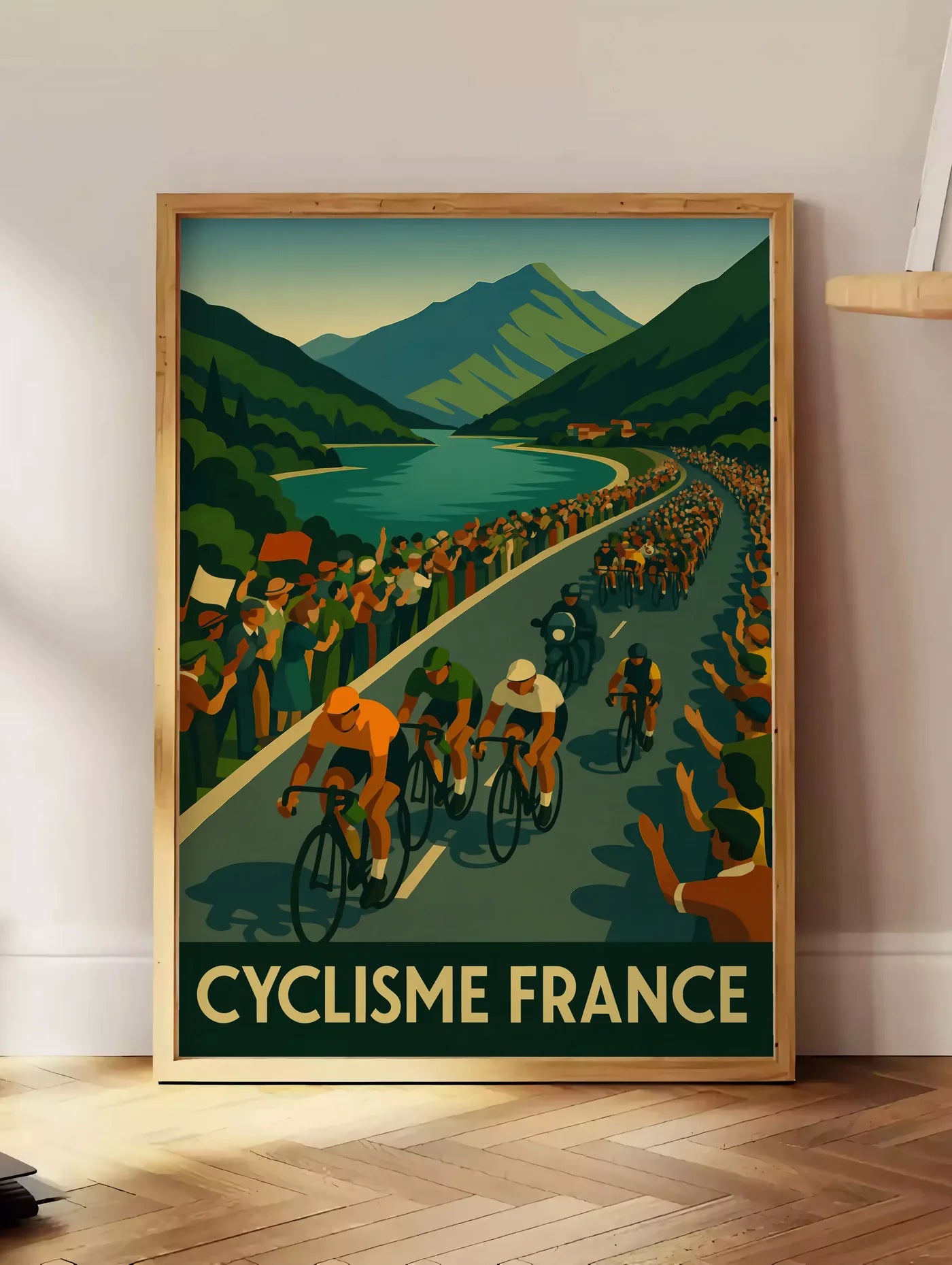 Estampe peloton de cyclistes longe un lac de montagne, posee au sol dans un coin salon, sur un parquet a chevrons, pres d'une table d'appoint en chene chargee de livres
