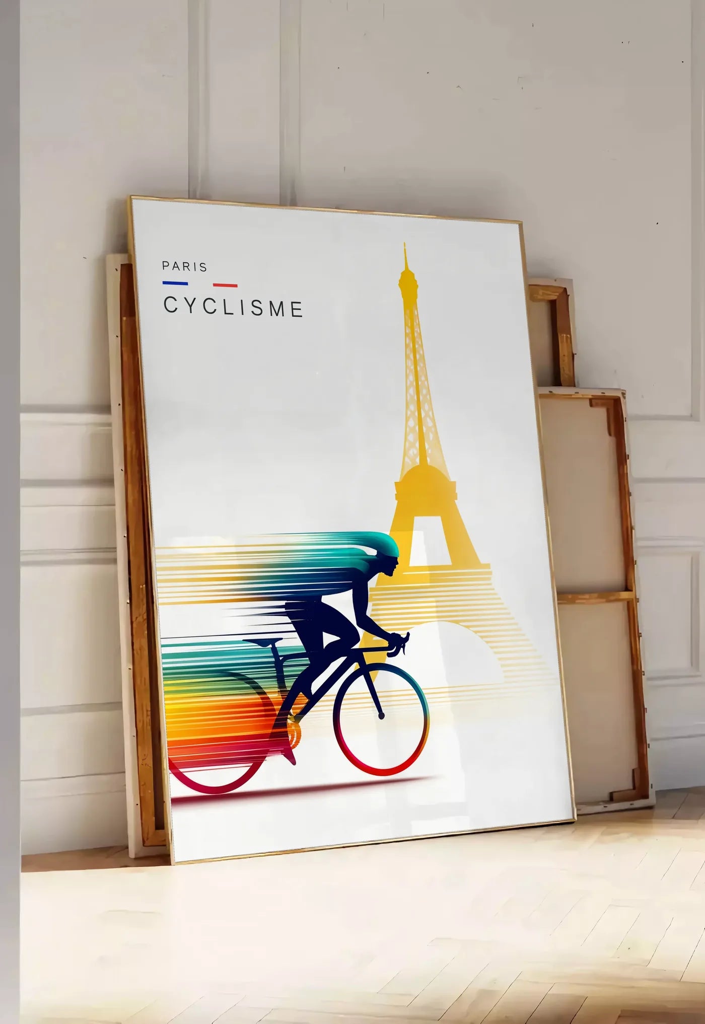Tirage encadrable cycliste stylisé en silhouette filée, posee au sol dans une entree lumineuse, contre un mur a panneaux blancs, a cote de chassis en bois empiles
