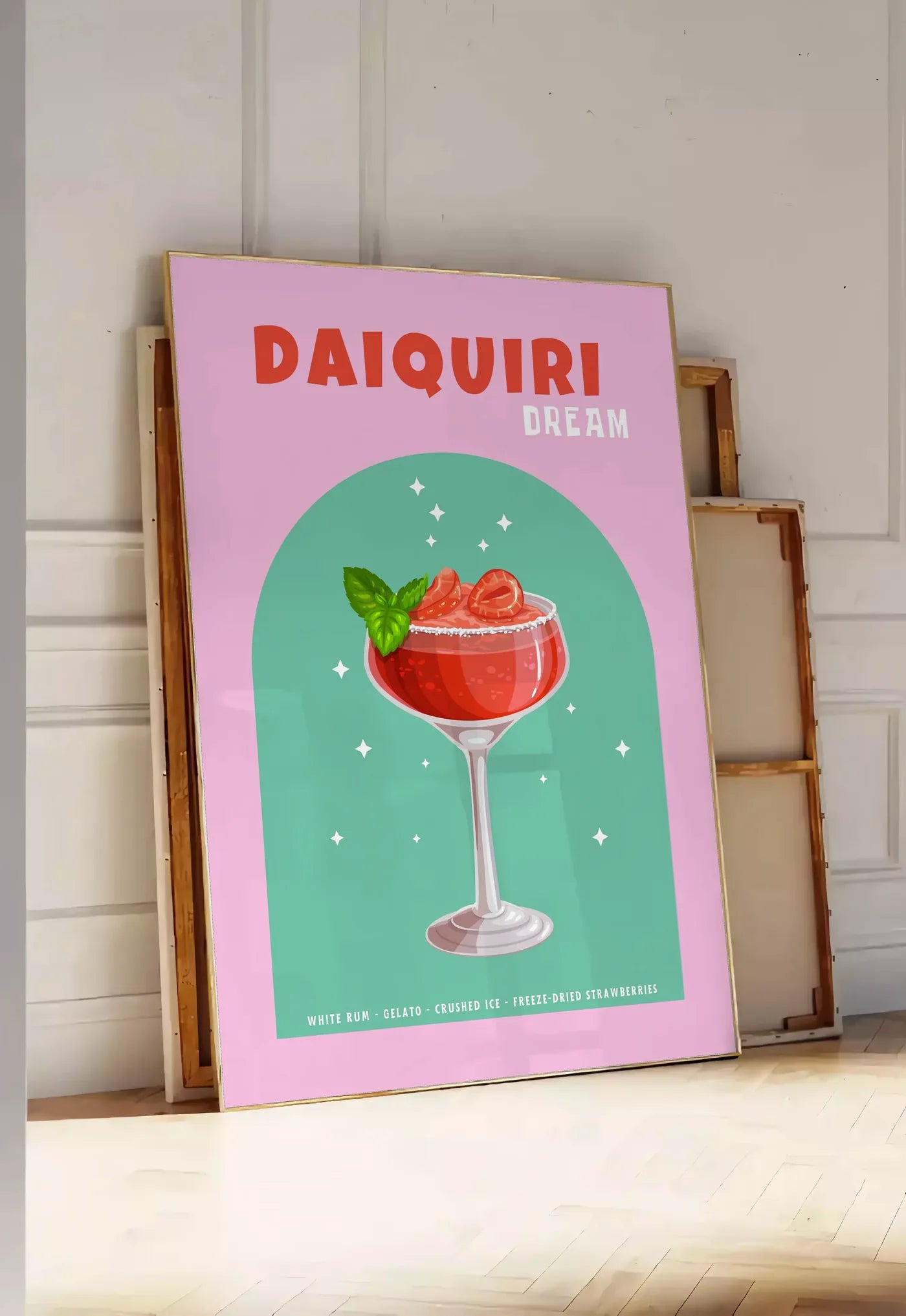 Tirage encadrable affiche cocktail Daiquiri fraise, posee au sol dans une entree lumineuse, contre un mur a panneaux blancs, a cote de chassis en bois empiles