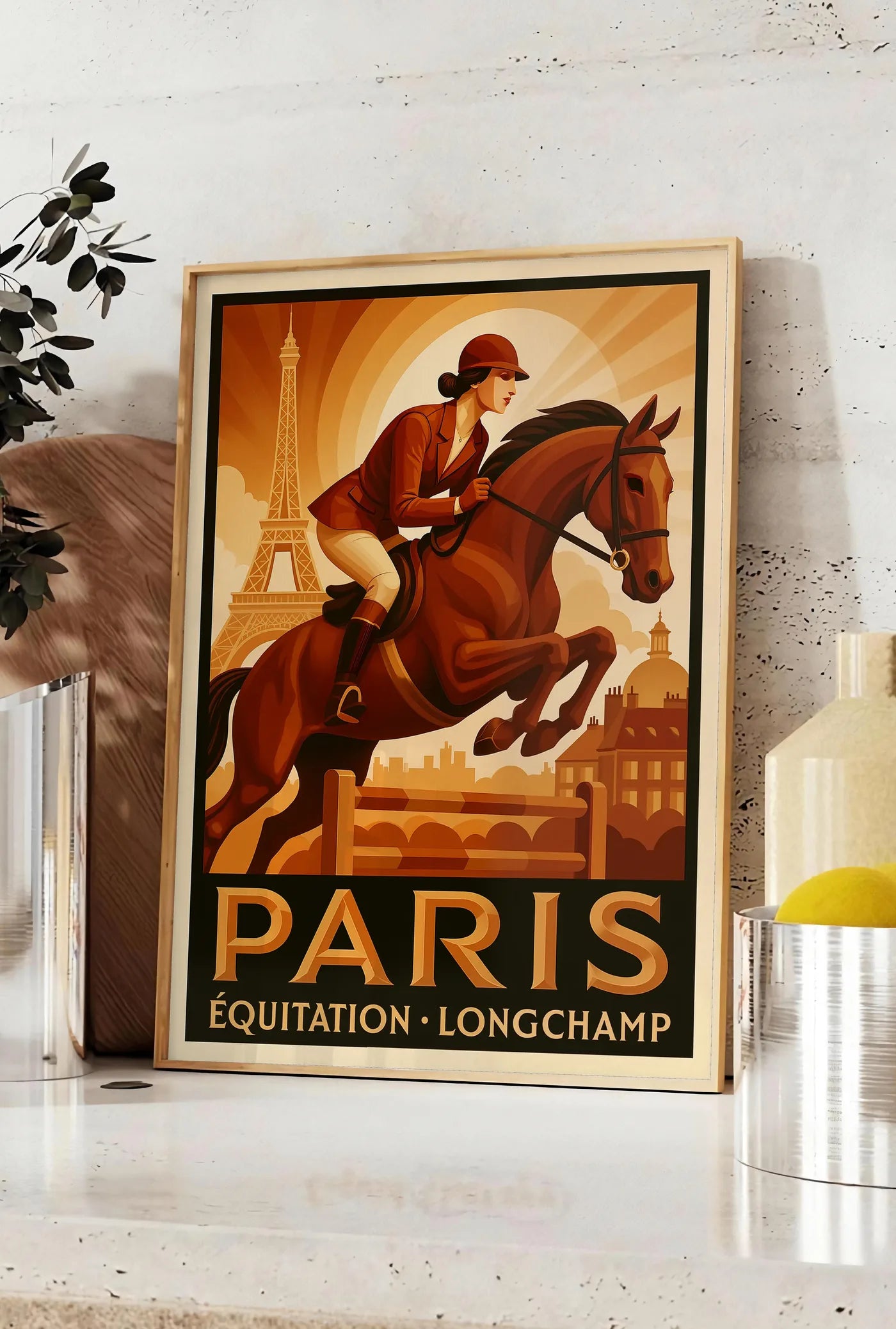 Affiche cavalière et cheval devant la Tour Eiffel, posee sur un plan de travail de cuisine en pierre claire, entre une branche d'eucalyptus en vase et un bocal de citrons