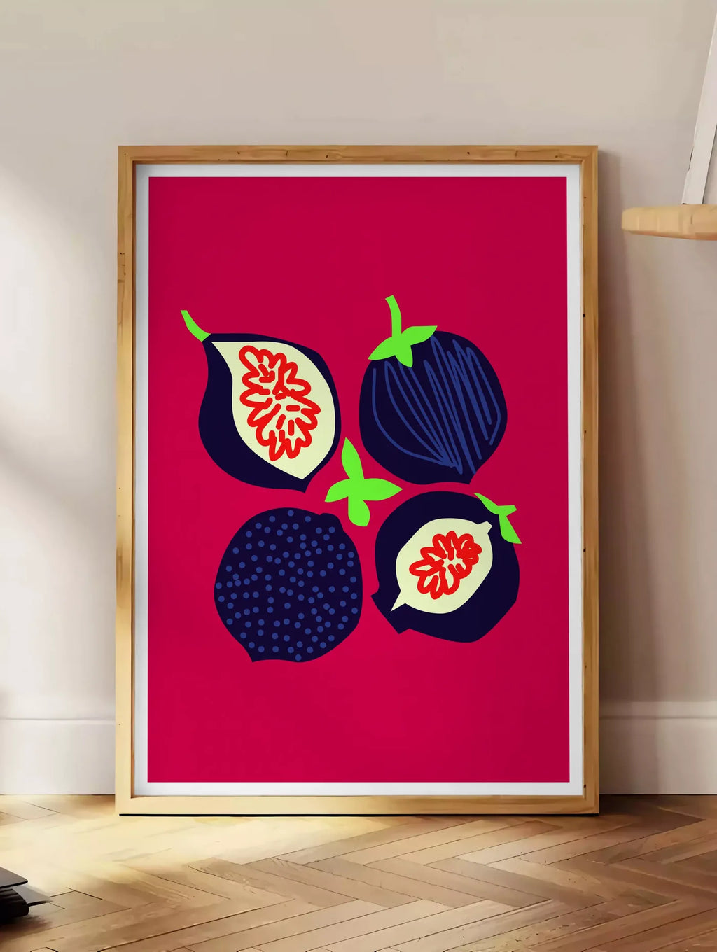 Estampe affiche cuisine figues fruit, posee au sol dans un coin salon, sur un parquet a chevrons, pres d'une table d'appoint en chene chargee de livres