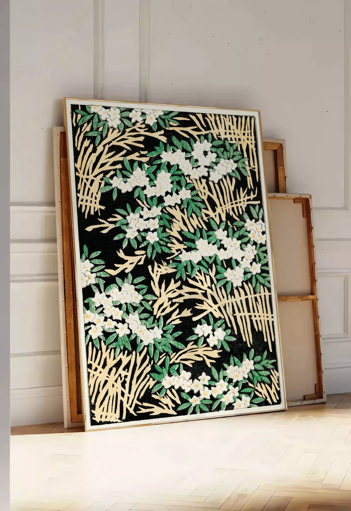 Tirage encadrable affiche fleurs blanches sur fond noir art japonais, posee au sol dans une entree lumineuse, contre un mur a panneaux blancs, a cote de chassis en bois empiles