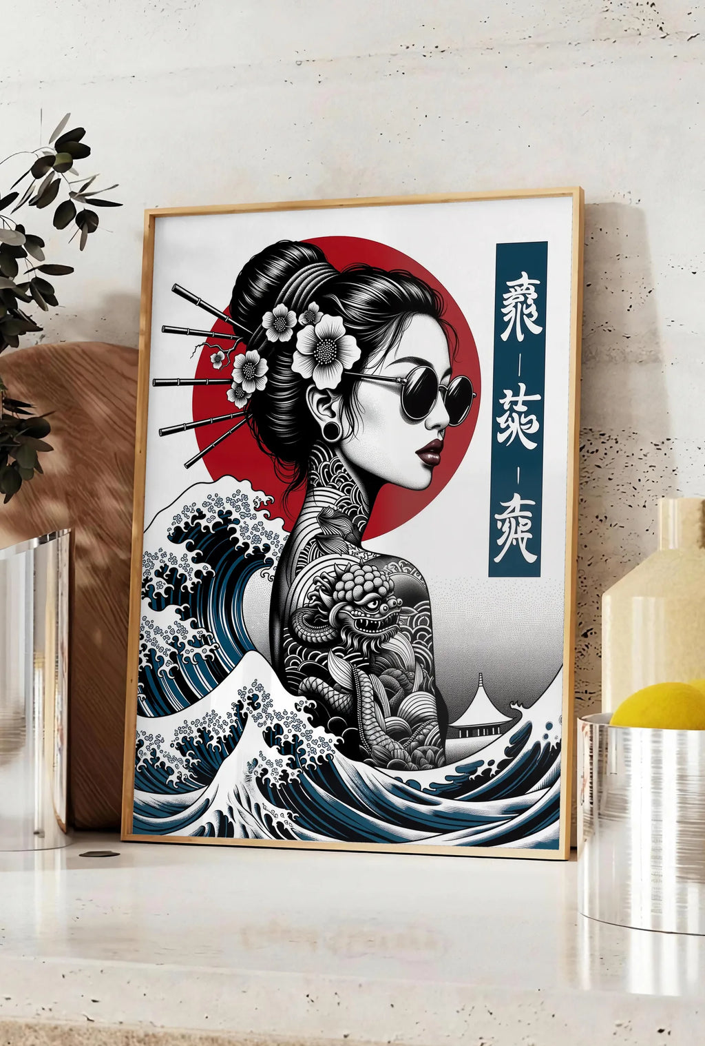 Affiche affiche geisha tatouee et vague art japonais, posee sur un plan de travail de cuisine en pierre claire, entre une branche d'eucalyptus en vase et un bocal de citrons