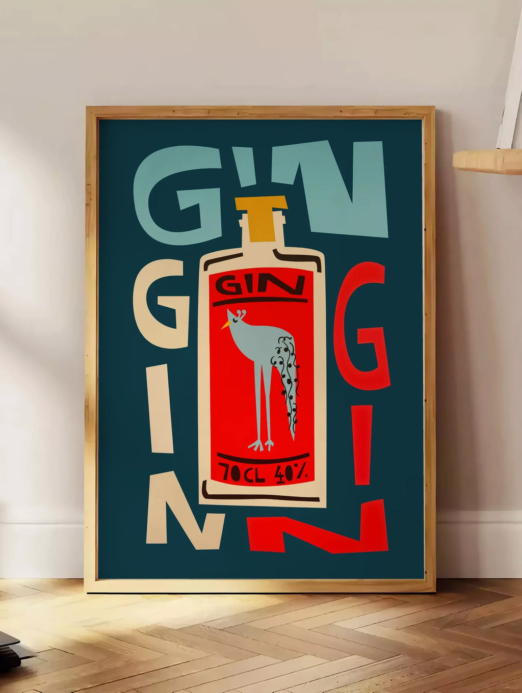 Estampe affiche cocktail gin, posee au sol dans un coin salon, sur un parquet a chevrons, pres d'une table d'appoint en chene chargee de livres